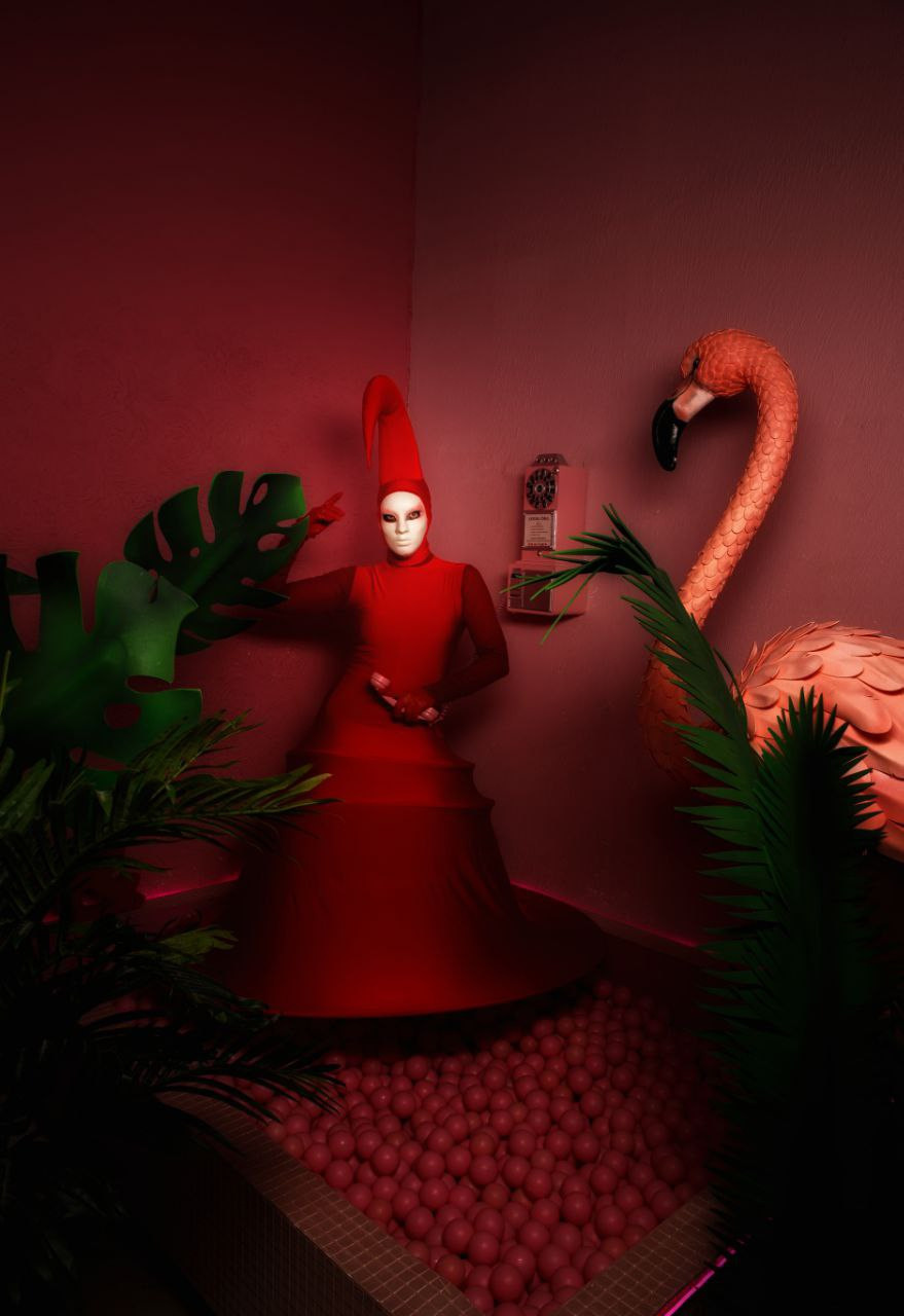 Мимы к красном костюме с фламинго на фотосессии в студии.