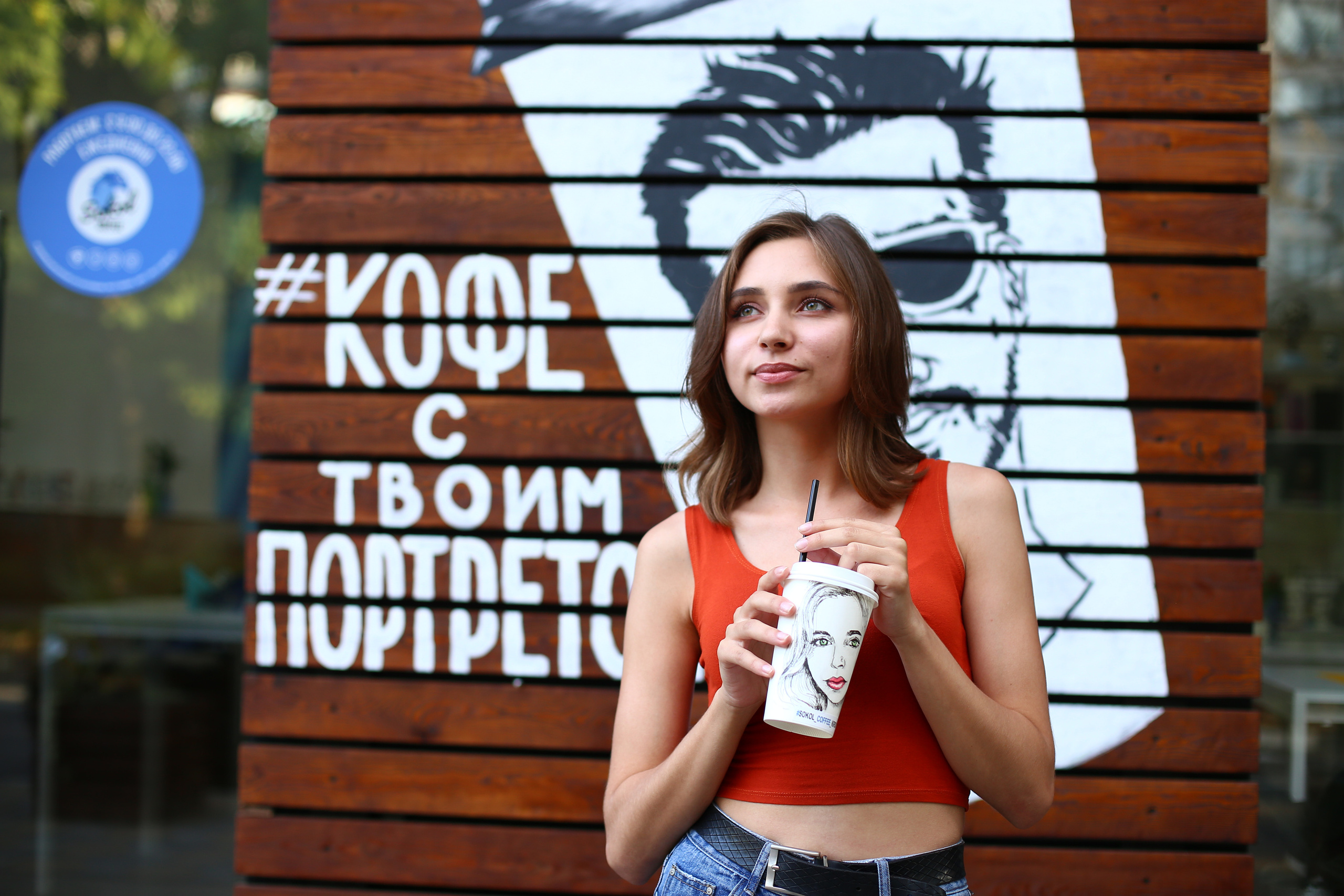 Девушка со стаканчиком кофе со своим лицом