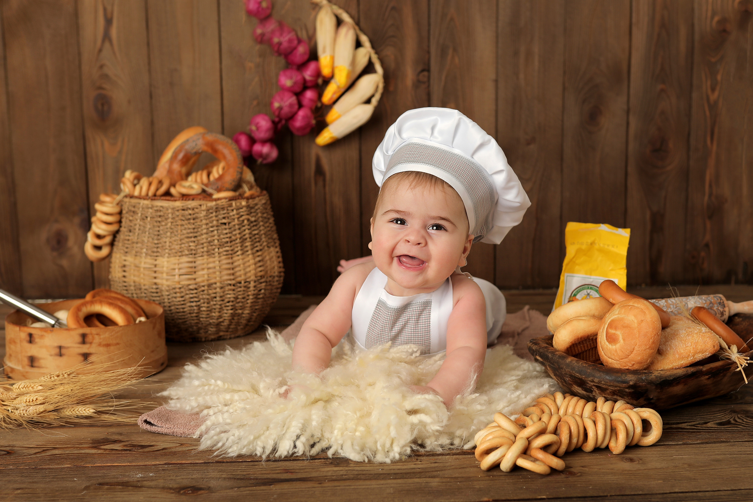 мальчик в костюме поваренка на коврике в студии с хлебом