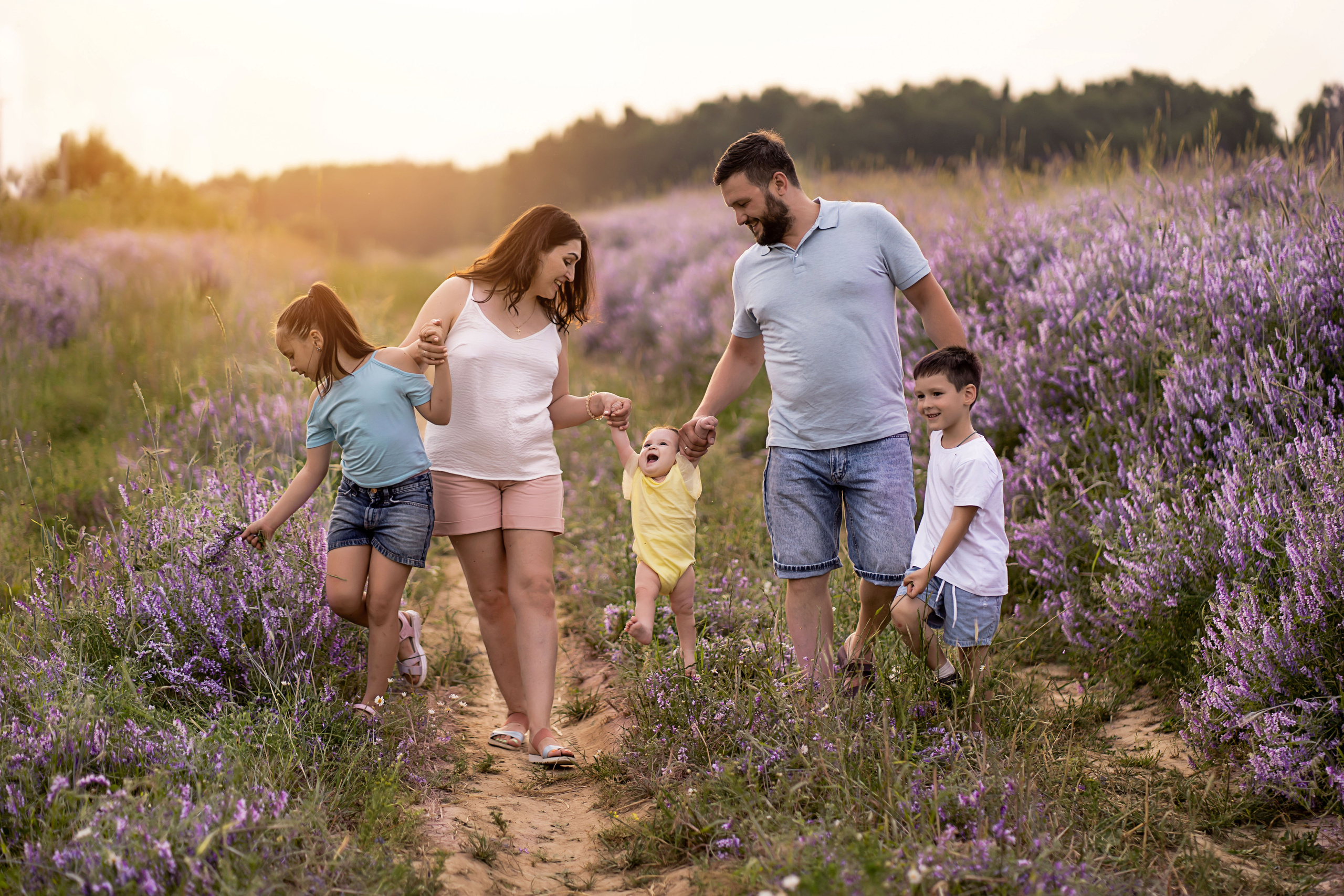 Счастливая семья среди фиолетовых цветов на лавандовом поле