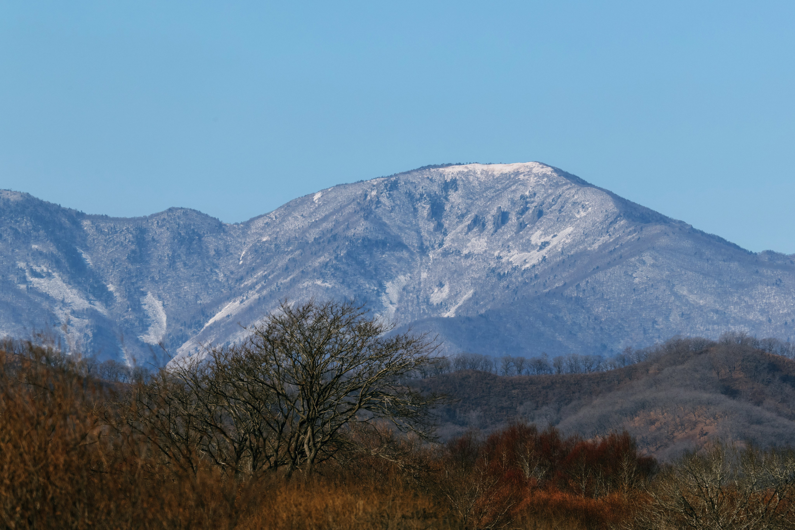 Как влияет атмосферная турбулентность на качество фото при съёмке далёких зимних пейзажей на телевик? Объяснение и пример снимка