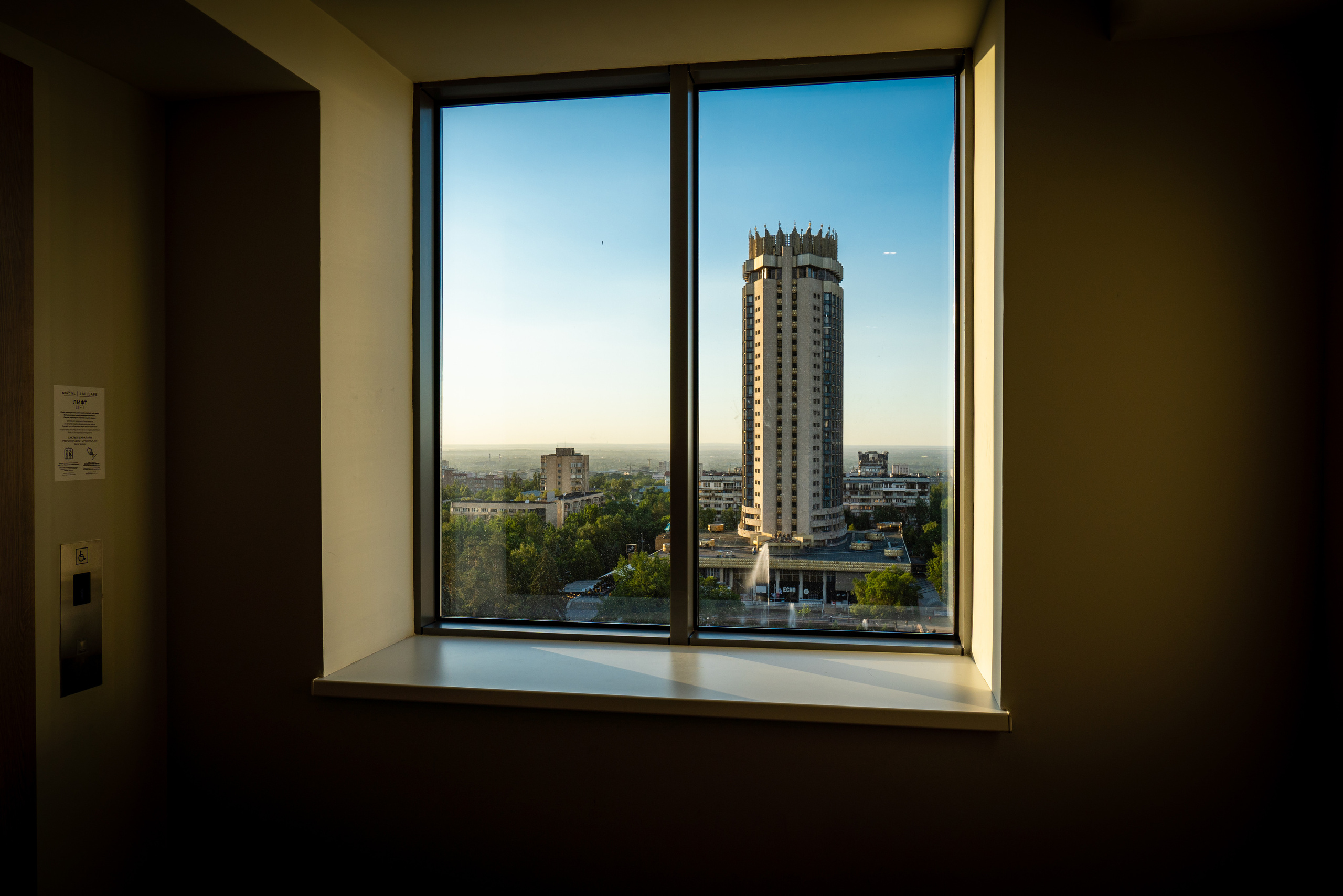 Окно в гостинице "Novotel" в Алматы с видом на гостиницу "Казахстан"