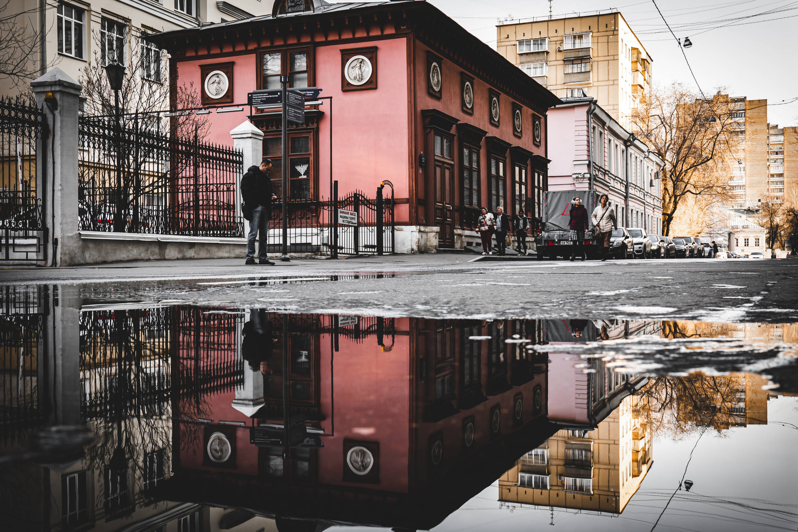 Здание и отражение в луже на Старом Арбате в Москве