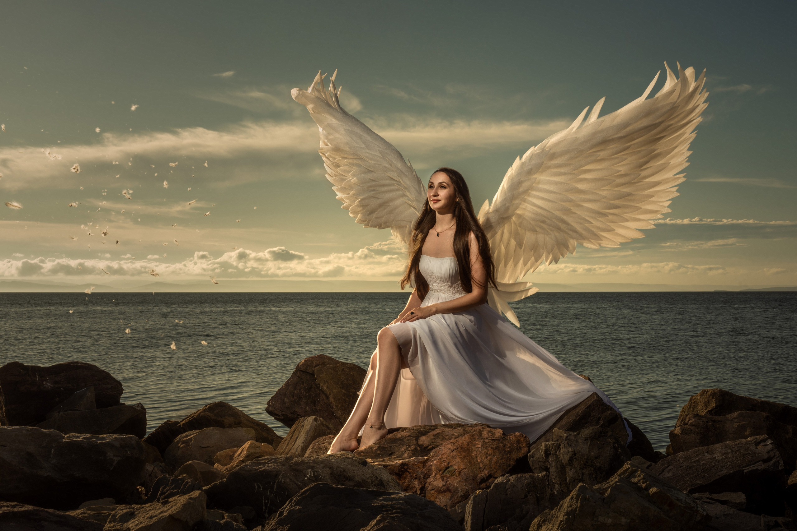 Сказочная фотосессия Владивосток - ангел с ангельскими крыльями на берегу моря наблюдает закат