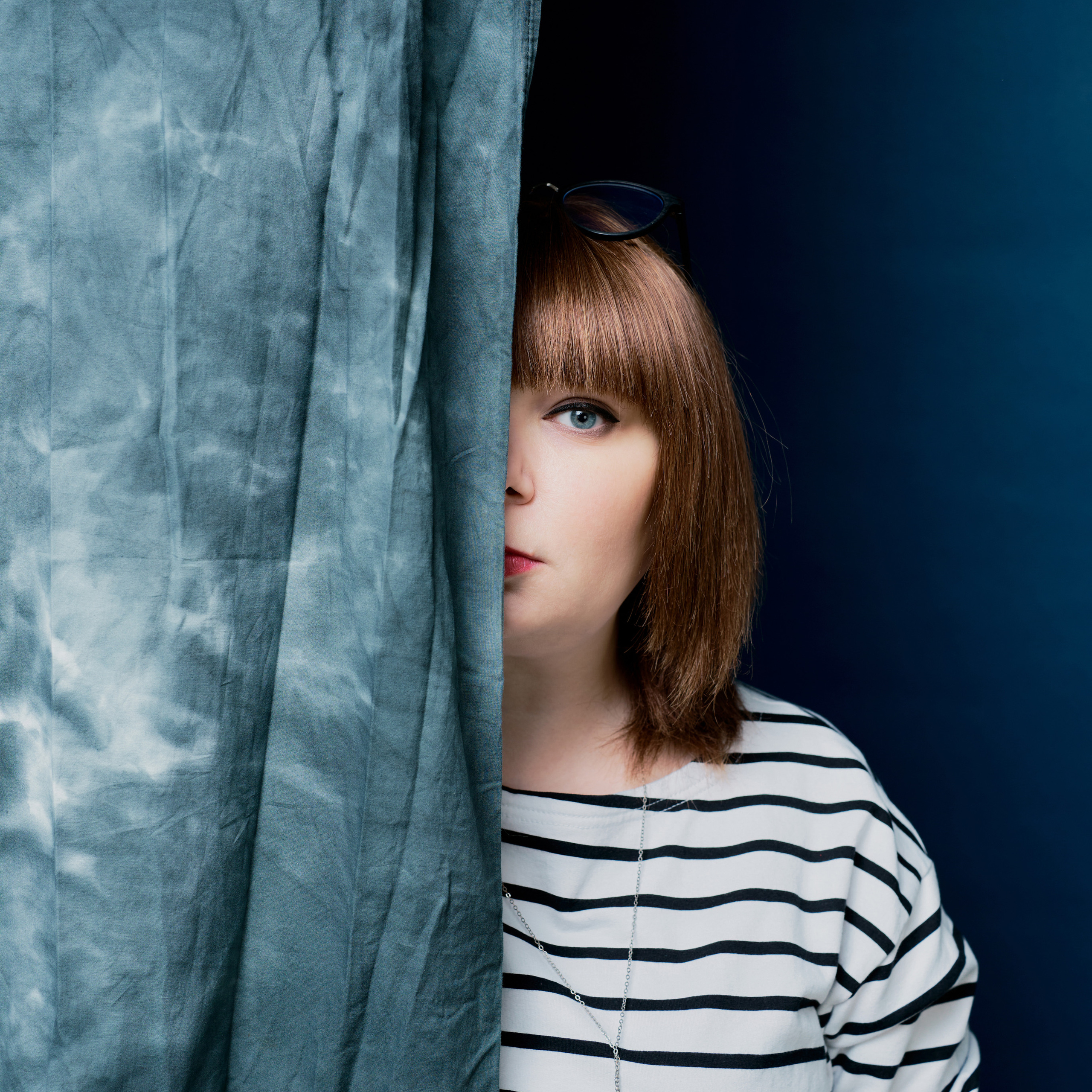 девушка в фотостудии выглядывает из за шторы портфолио для коуча фото для соцсетей