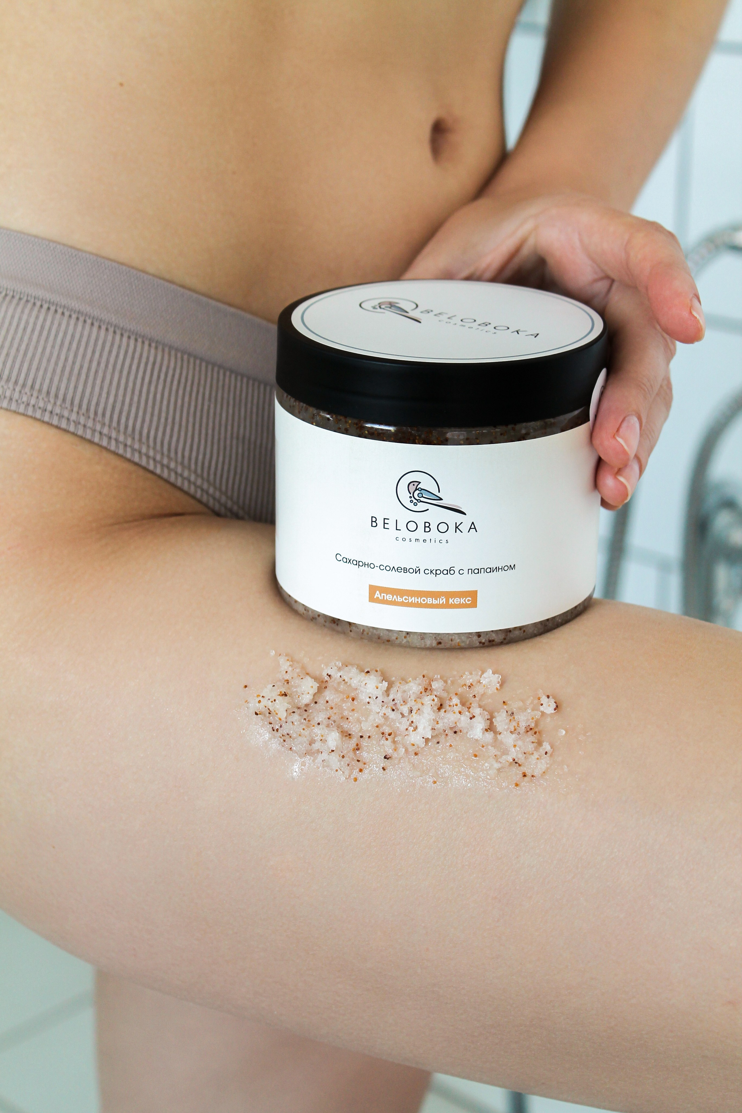 девушка держит скраб для тела в ванной комнате. Предметный фотограф