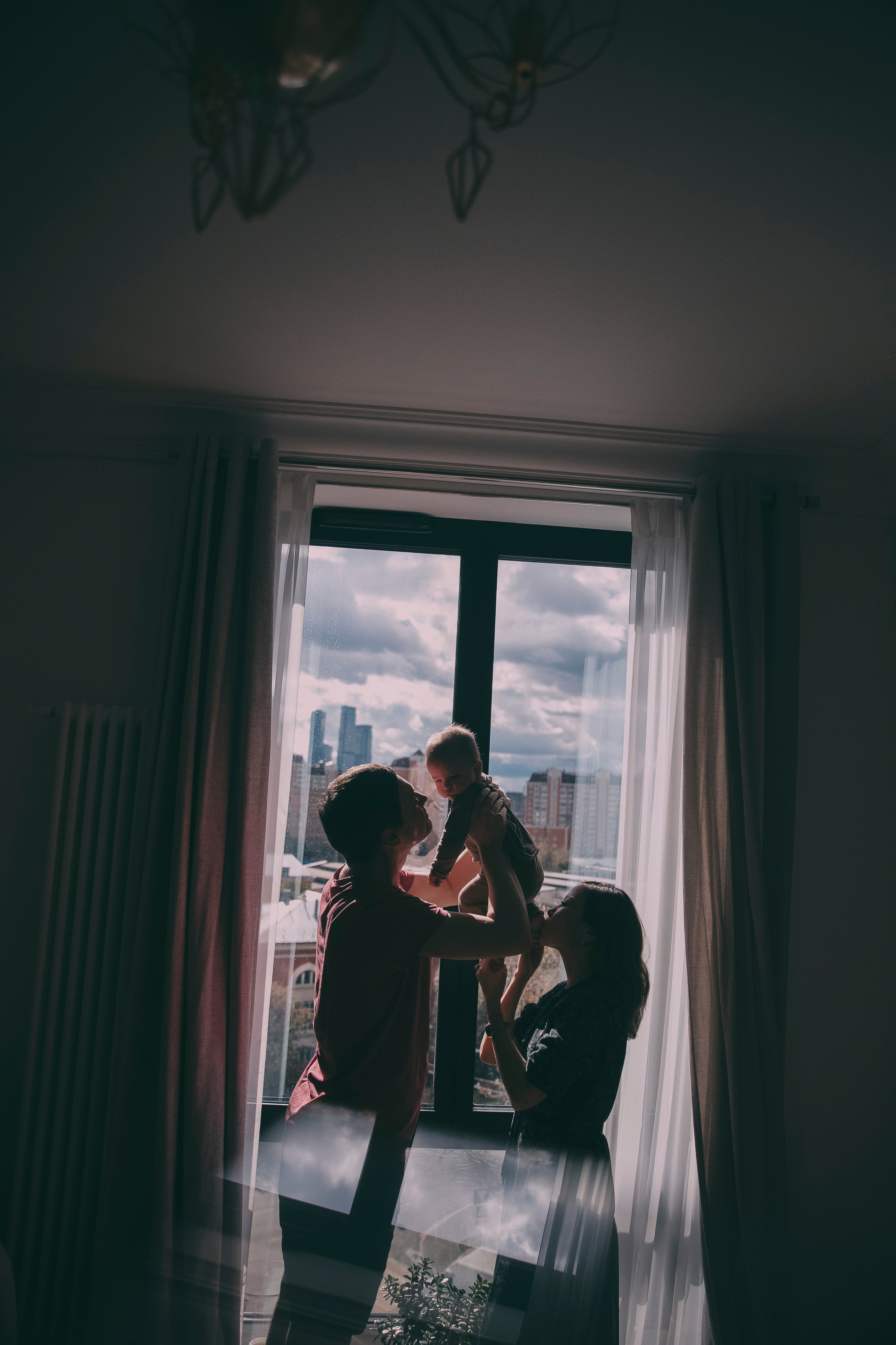 Красивая молодая семья дома дома играет со своим любимым малышом