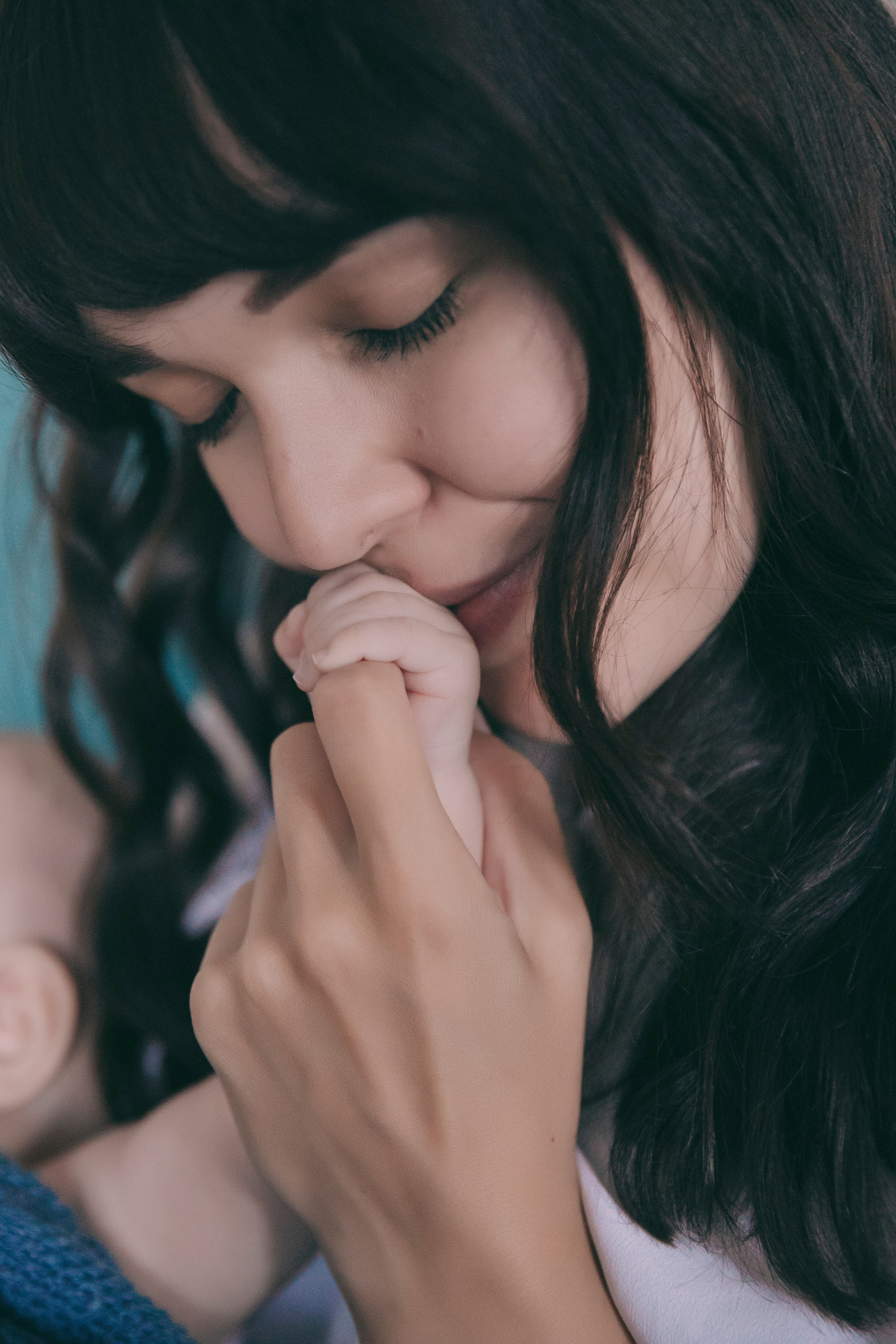 Молодая  красивая мама  целует своего маленького малыша