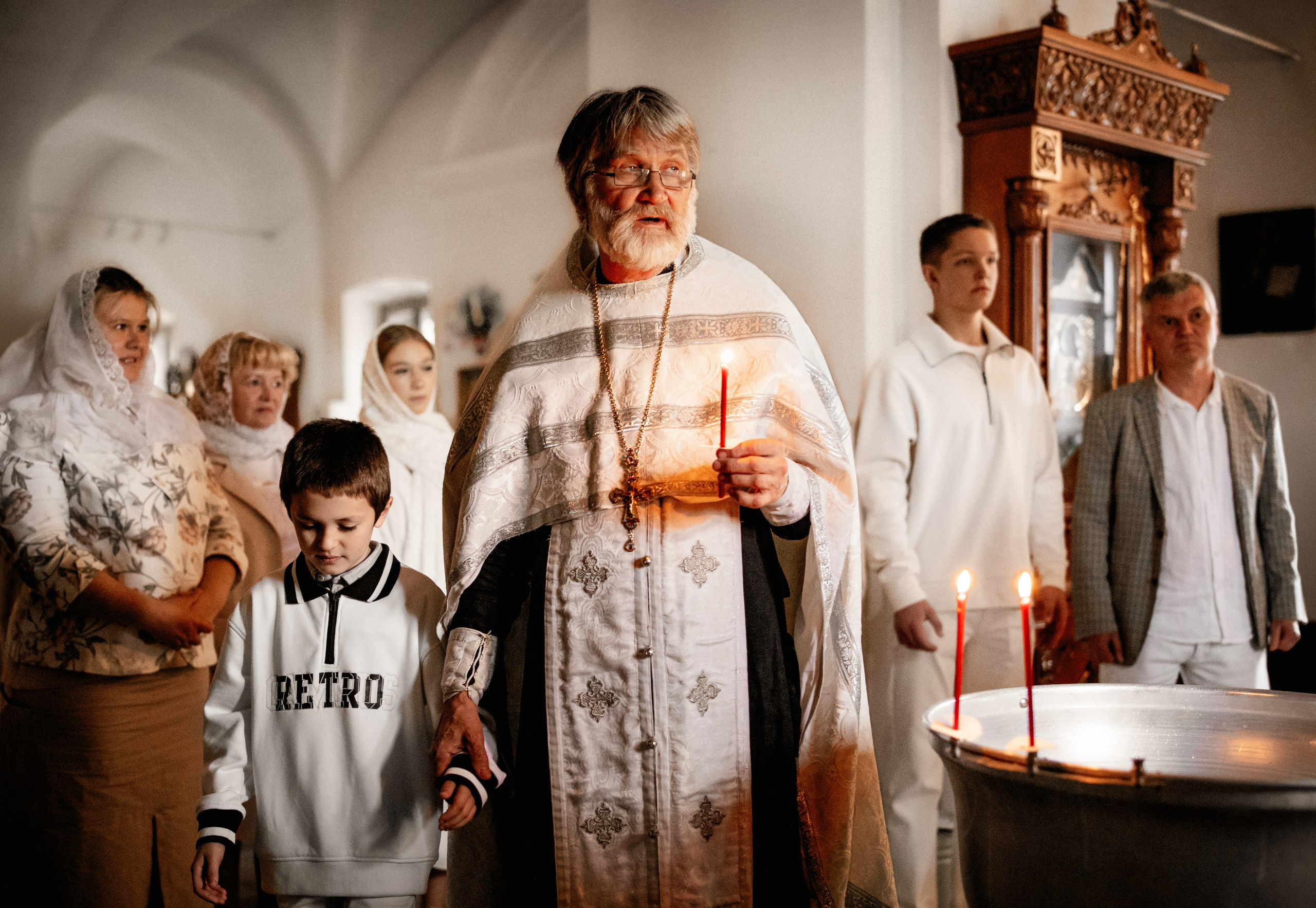 Фотография батюшки и ребенка во время таинства крещения