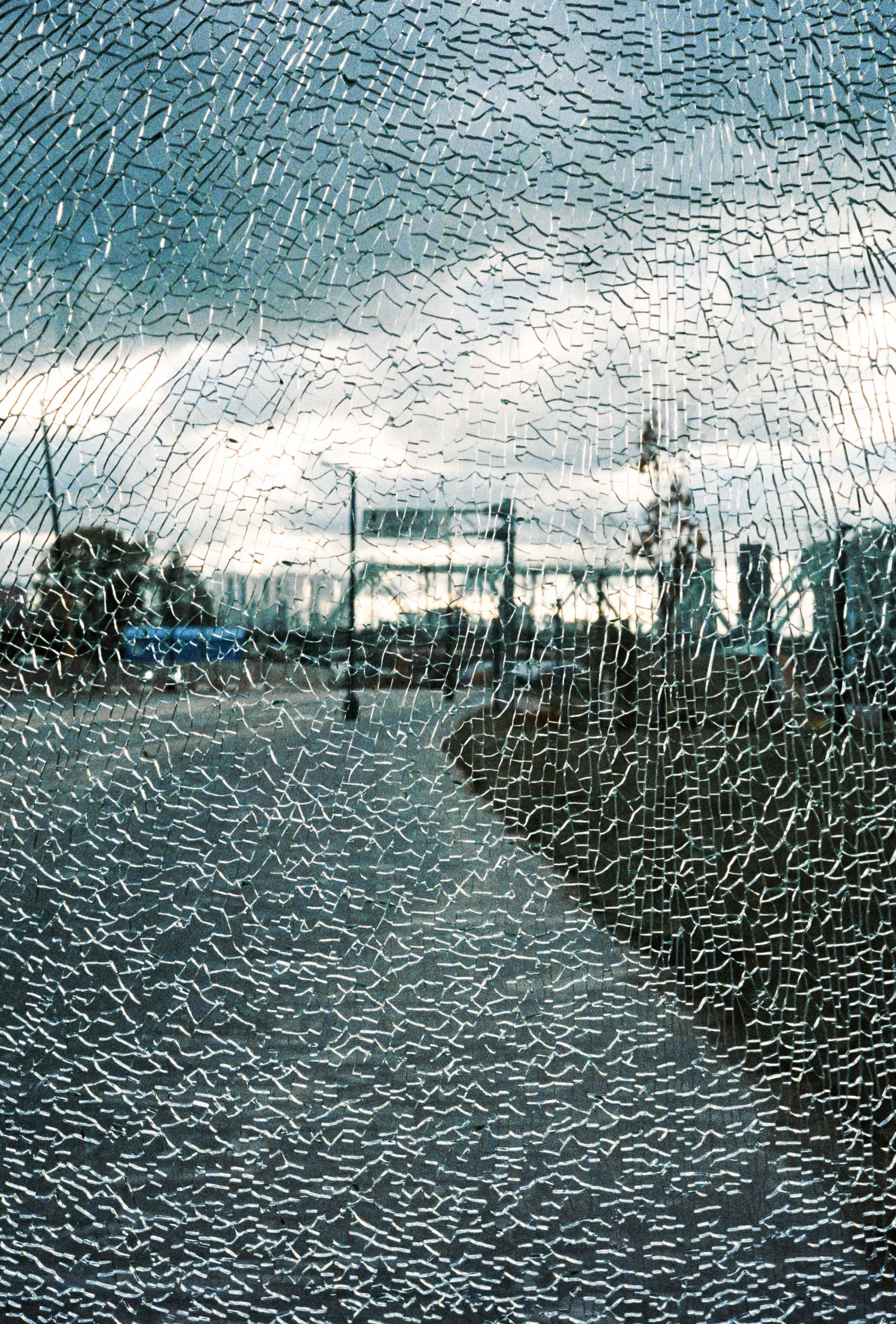 Вид на город через разбитое стекло остановки общественного транспорта