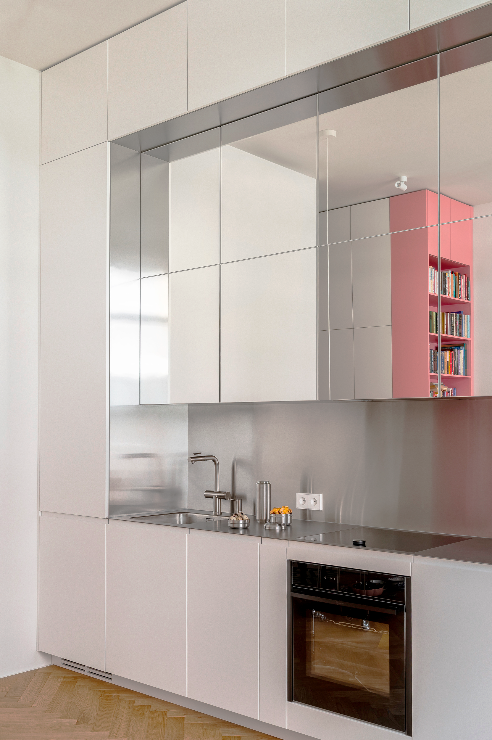 Kitchen cabinets with mirrored fronts and pink shelving