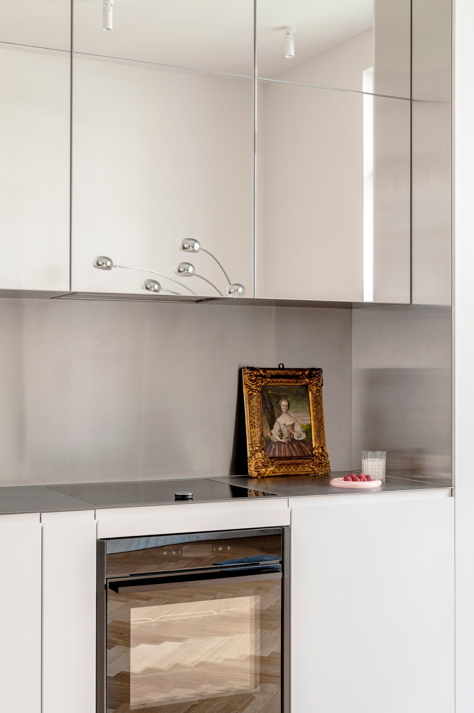 Built-in oven and mirrored upper kitchen cabinets