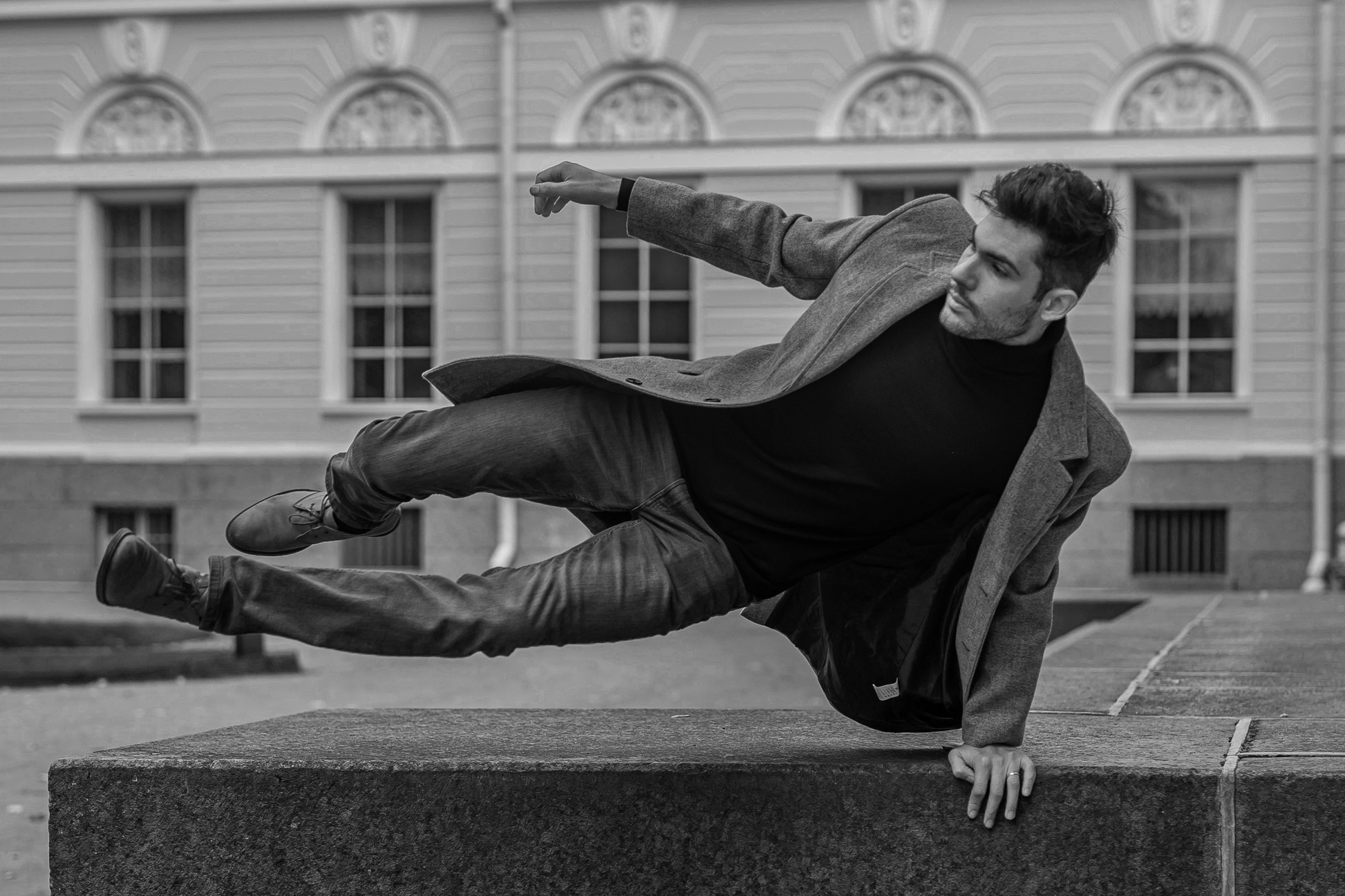 Молодой джентльмен в прыжке оперся рукой о гранитный пьедестал