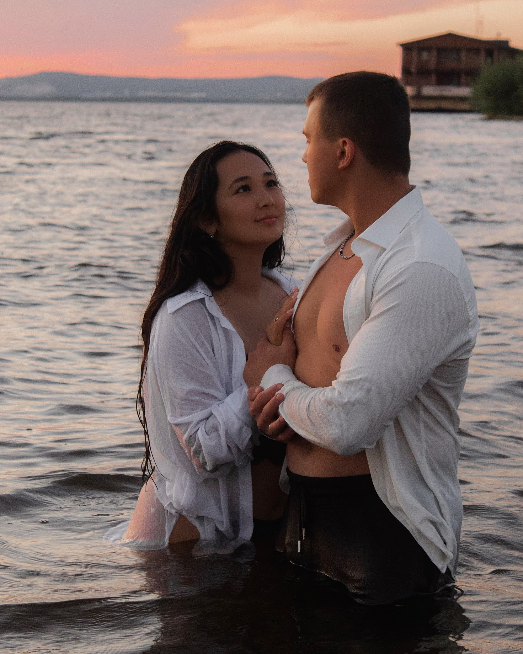 парень и девушка смотрят друг на друга в воде на закате