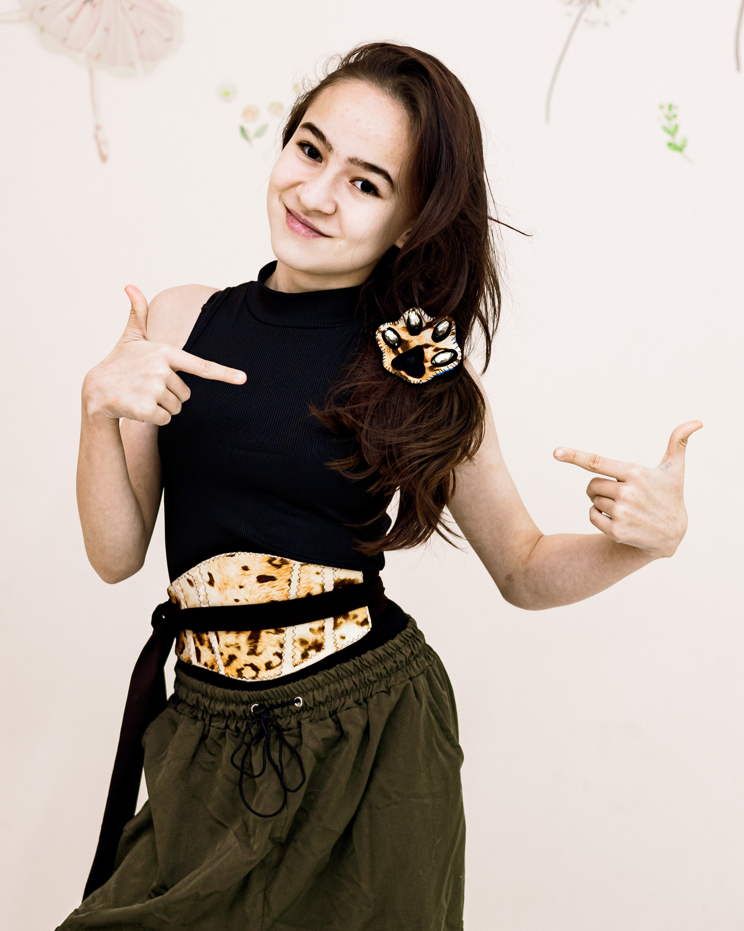 Девочка сшила брошь и пояс-кушак в стиле сафари и с удовольствием демонстрирует их на фотосессии