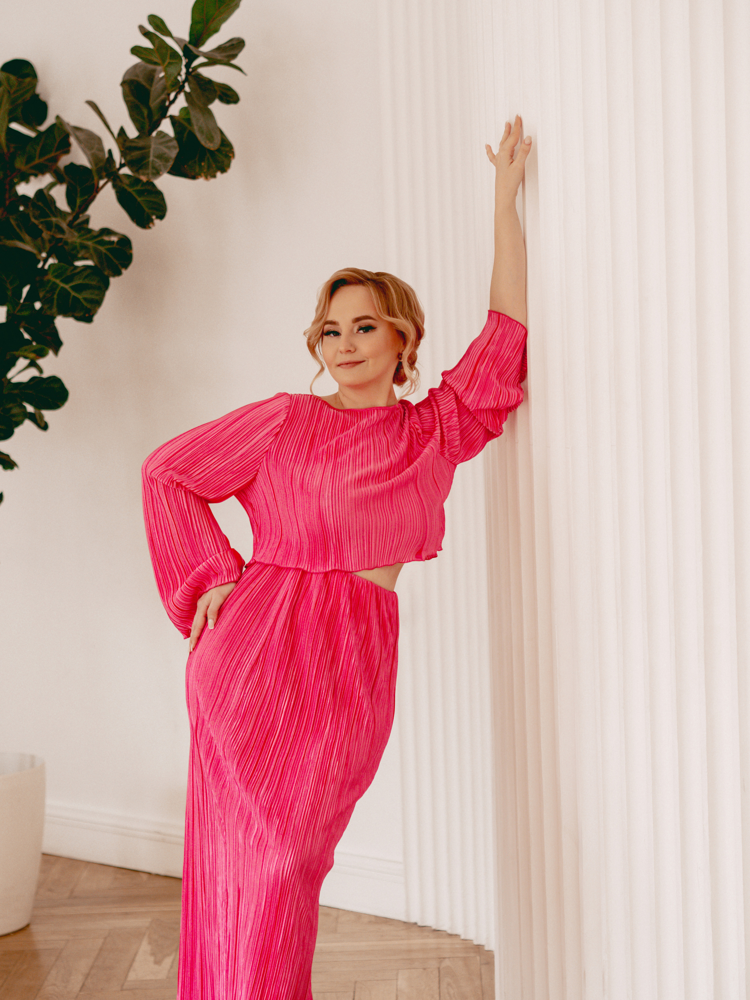 девушка в фотостудии облокачивается на стену