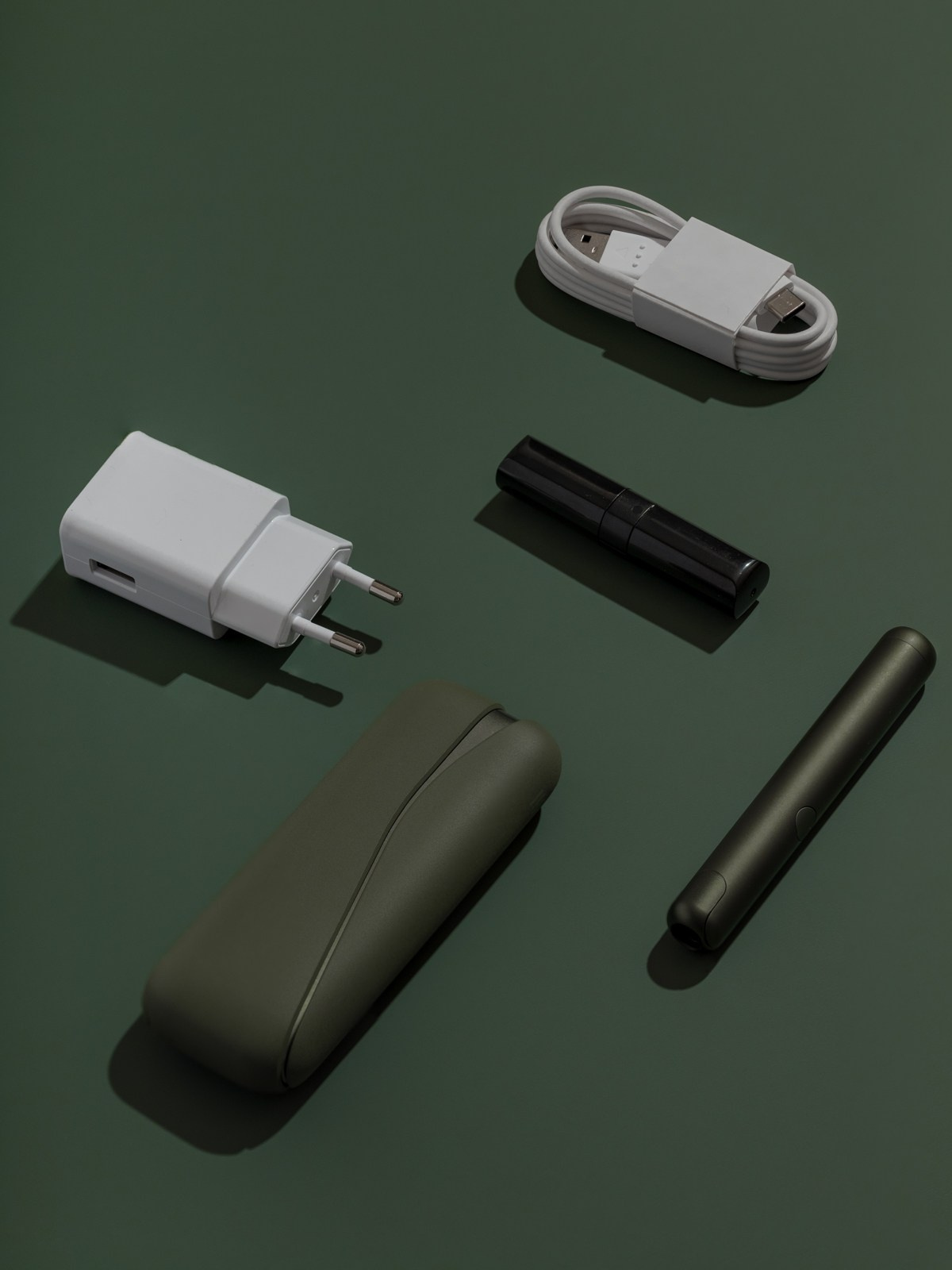 Предметная съёмка устройства IQOS на круглой подставке с акцентом на форму и цвет