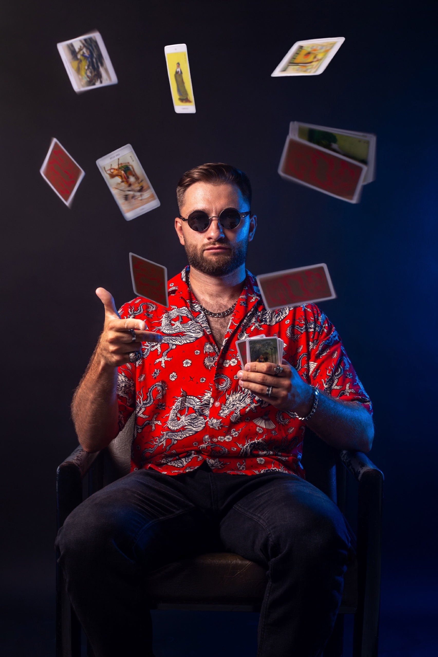 Студийная фотосессия: мужчина в красной рубашке с картами таро