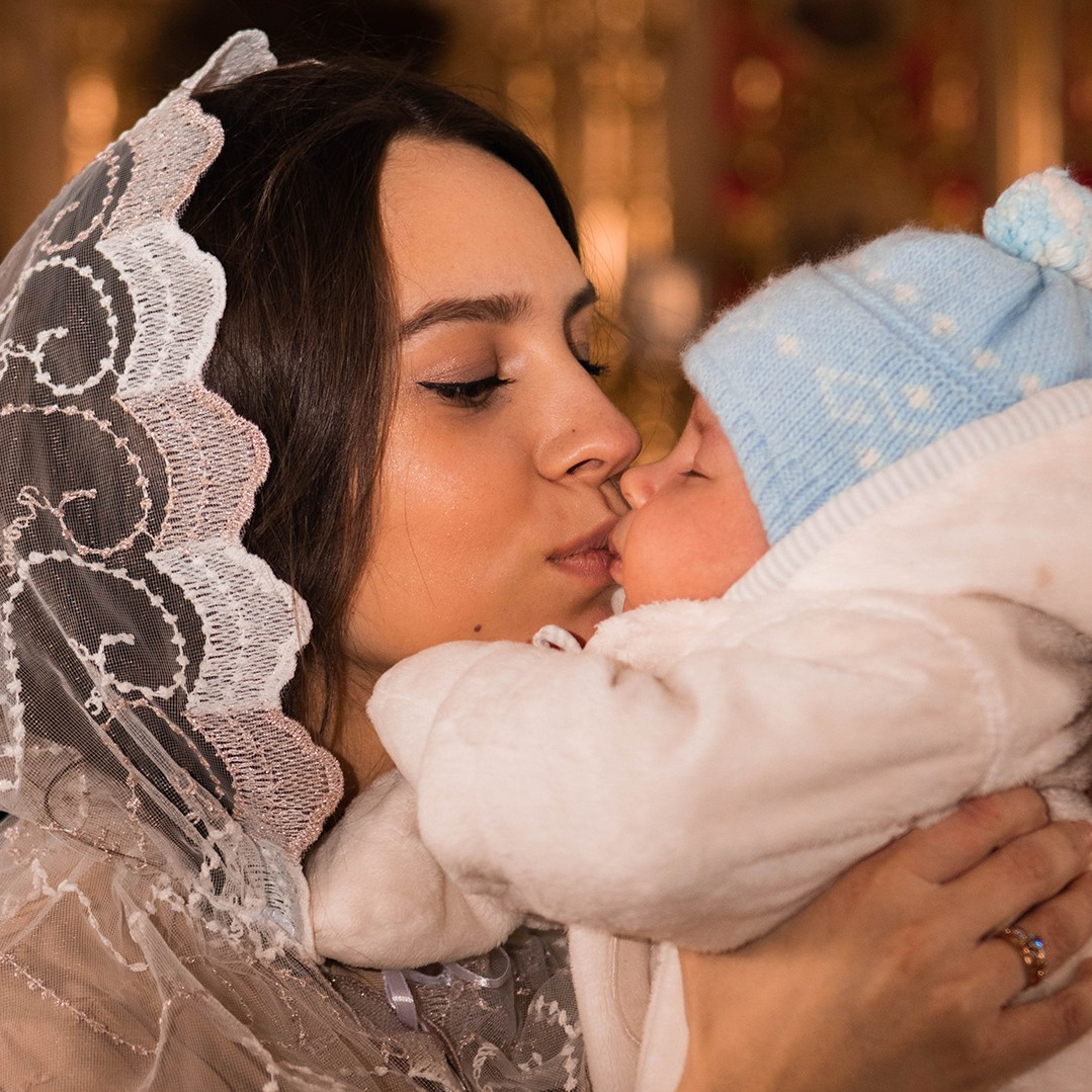 Мама нежится с новорожденным после крещения