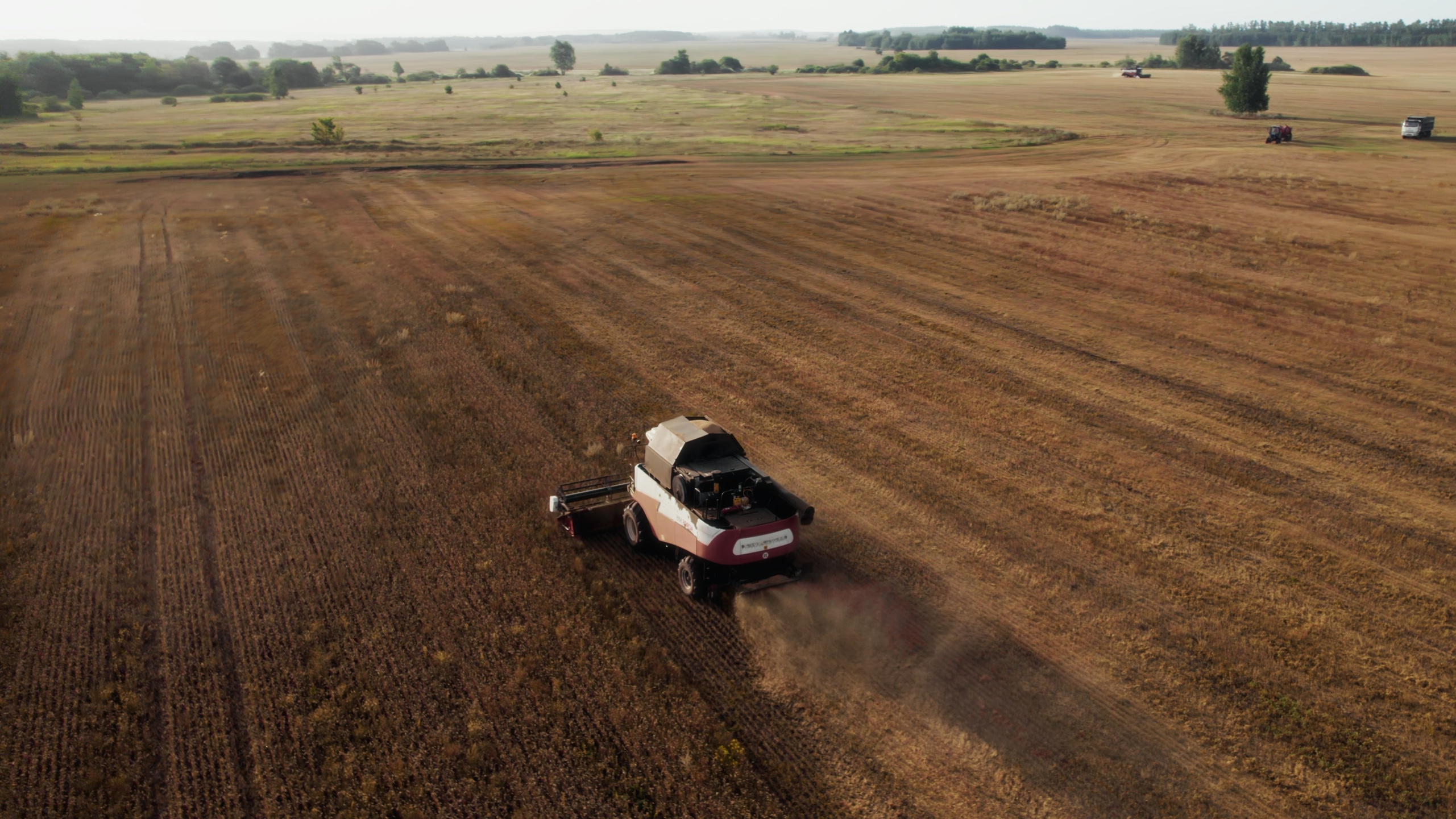 Съемка полей с коптера, трактор собирает урожай в Пензенской области