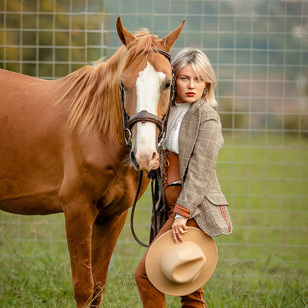 Рыжая лошадь с девушкой блондинкой на фоне гор