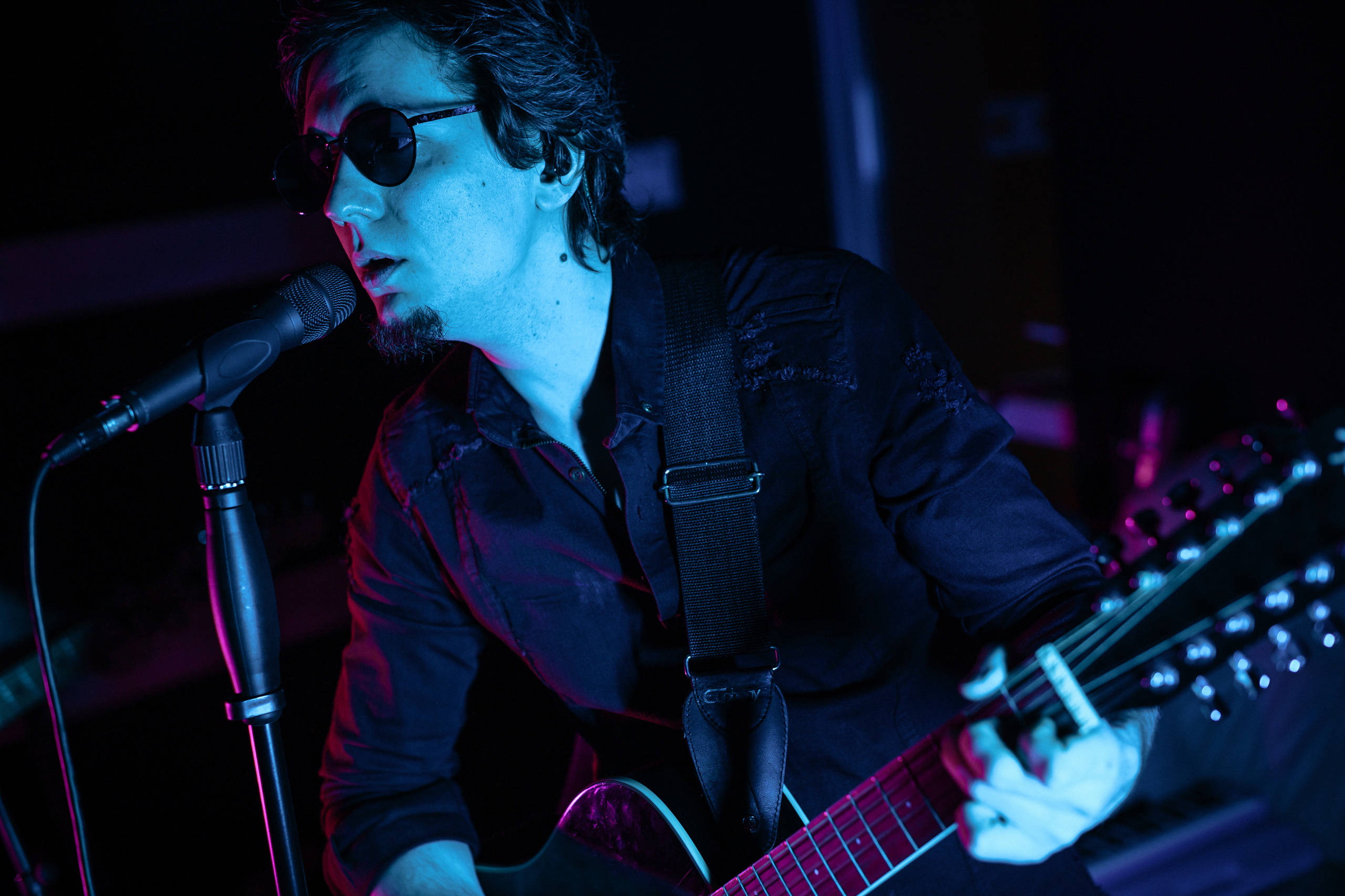 Мужчина с гитарой в неоновом свете