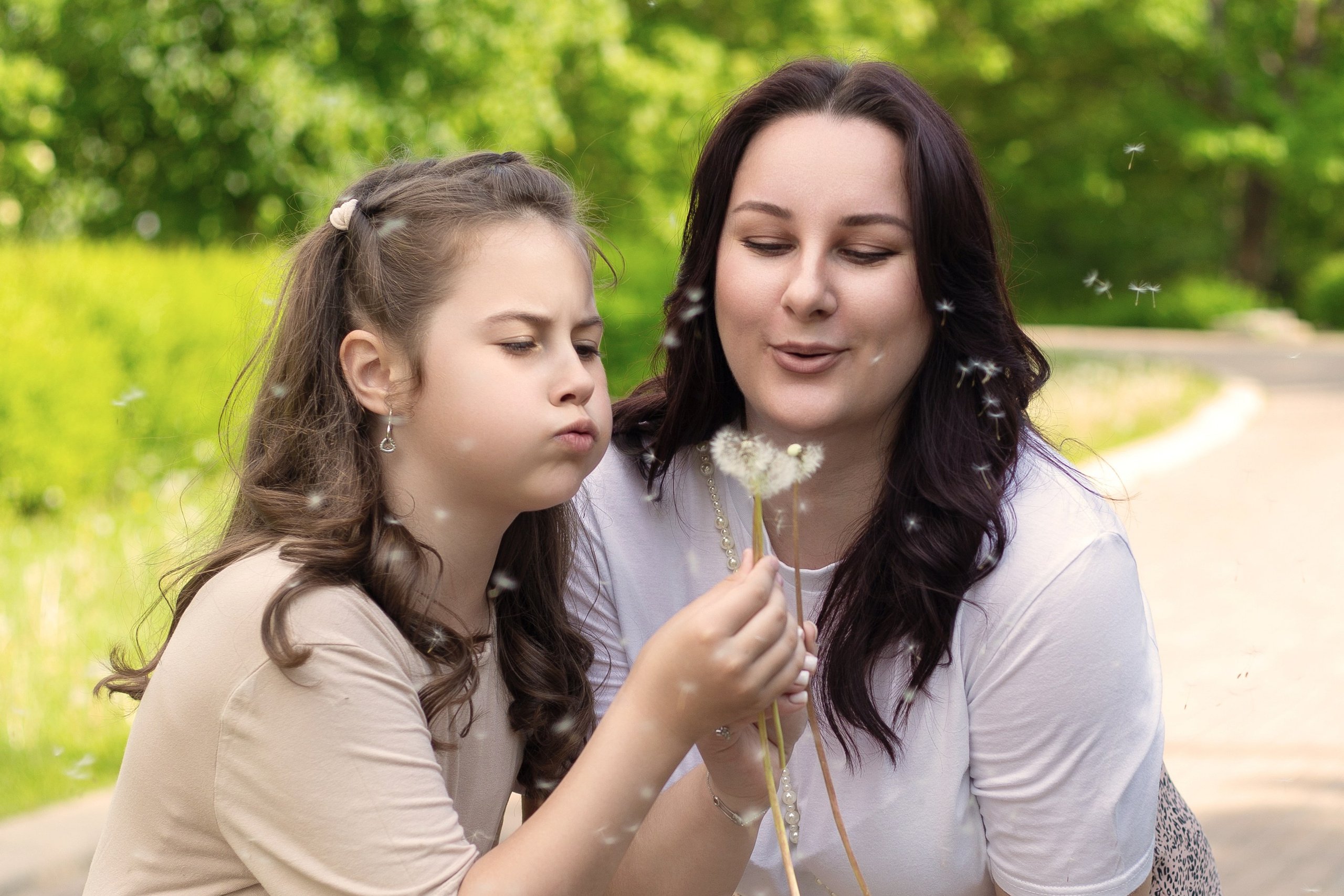 молодая женщина сидит с девочкой и мальчиком в игрушечном вигваме на фоне зимнего синего неба