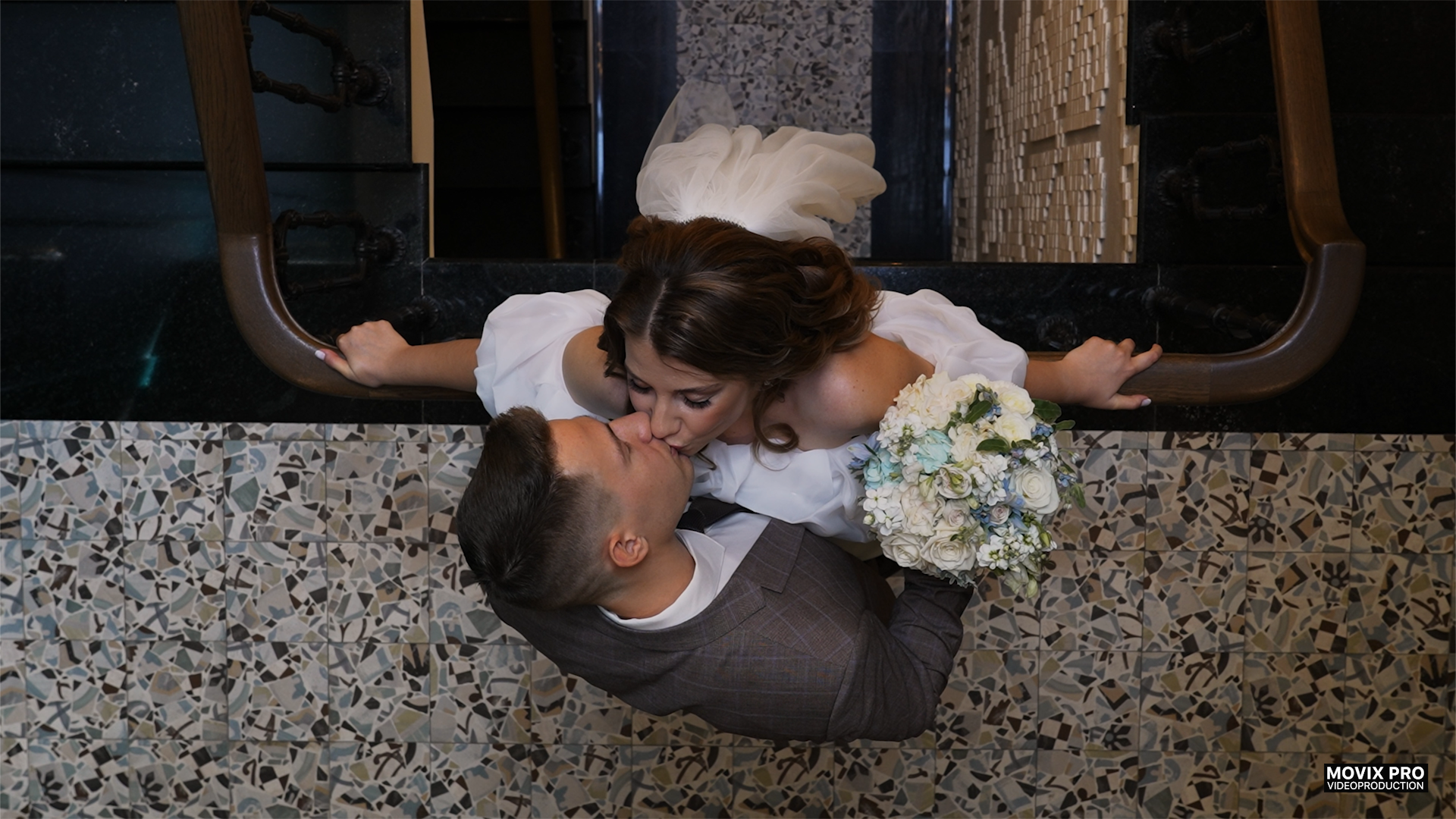 Жених целует невесту на красивой лестнице, вид сверху