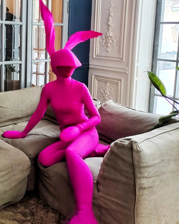 Мим-зайчик в обтягивающем костюме на встрече гостей в ресторане.