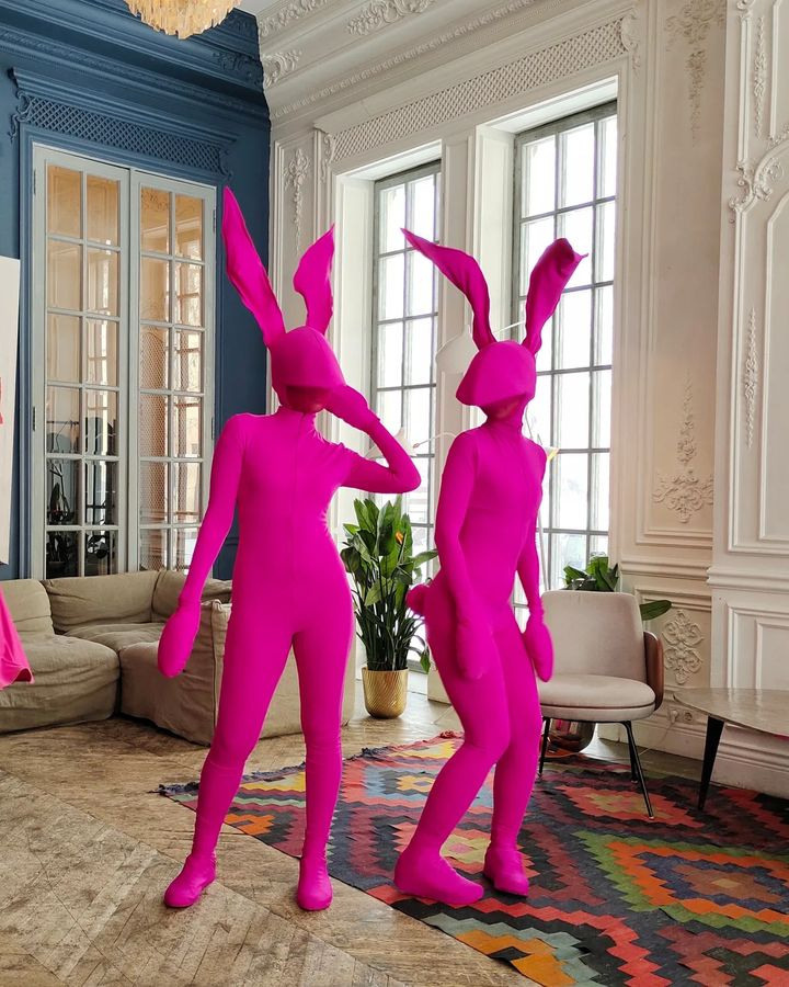 Мимы в костюмах зайцев на хэллоуин на встрече гостей в ресторане.