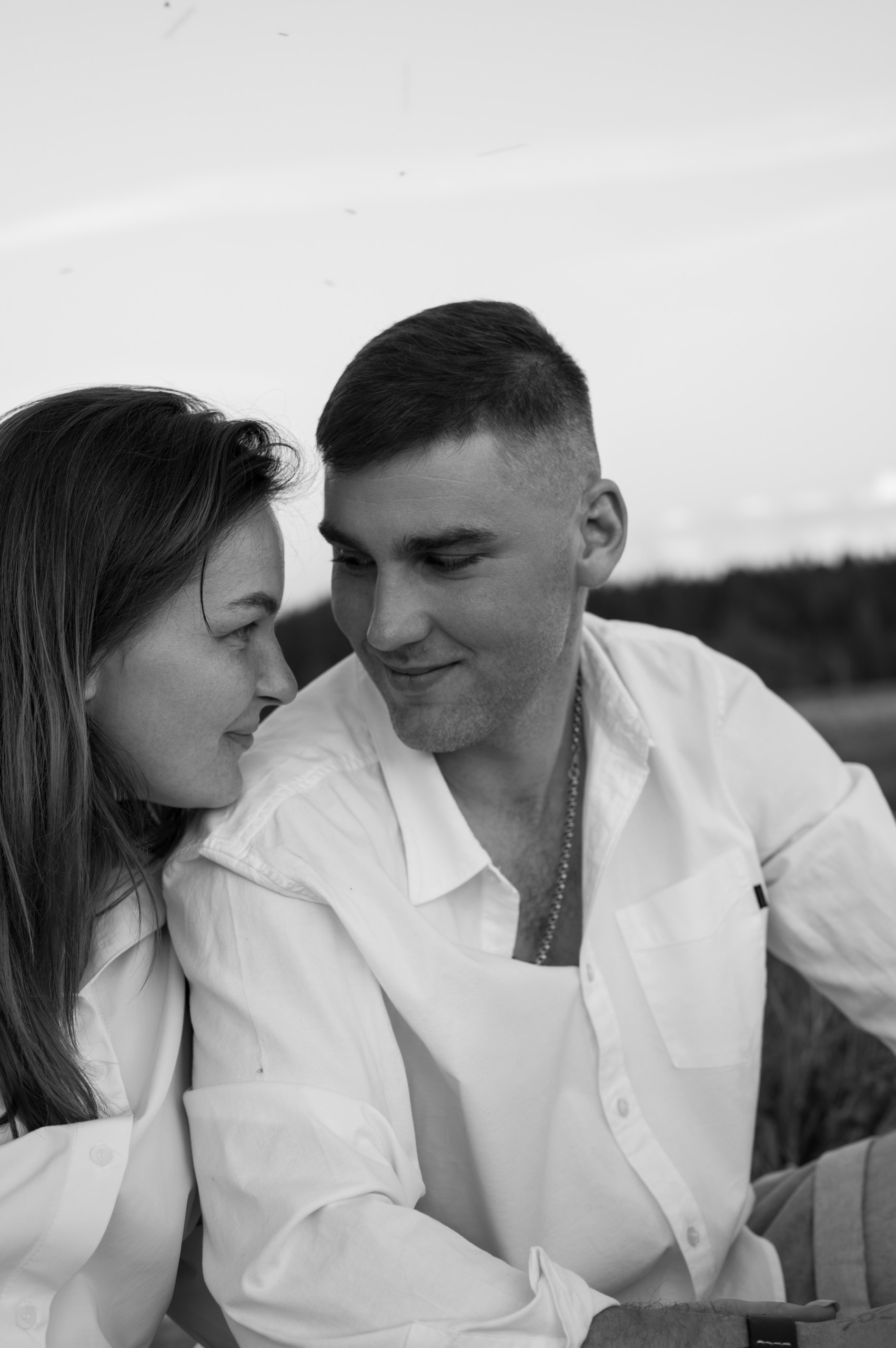 Расслабленная пара улыбается в камеру на фотосессии