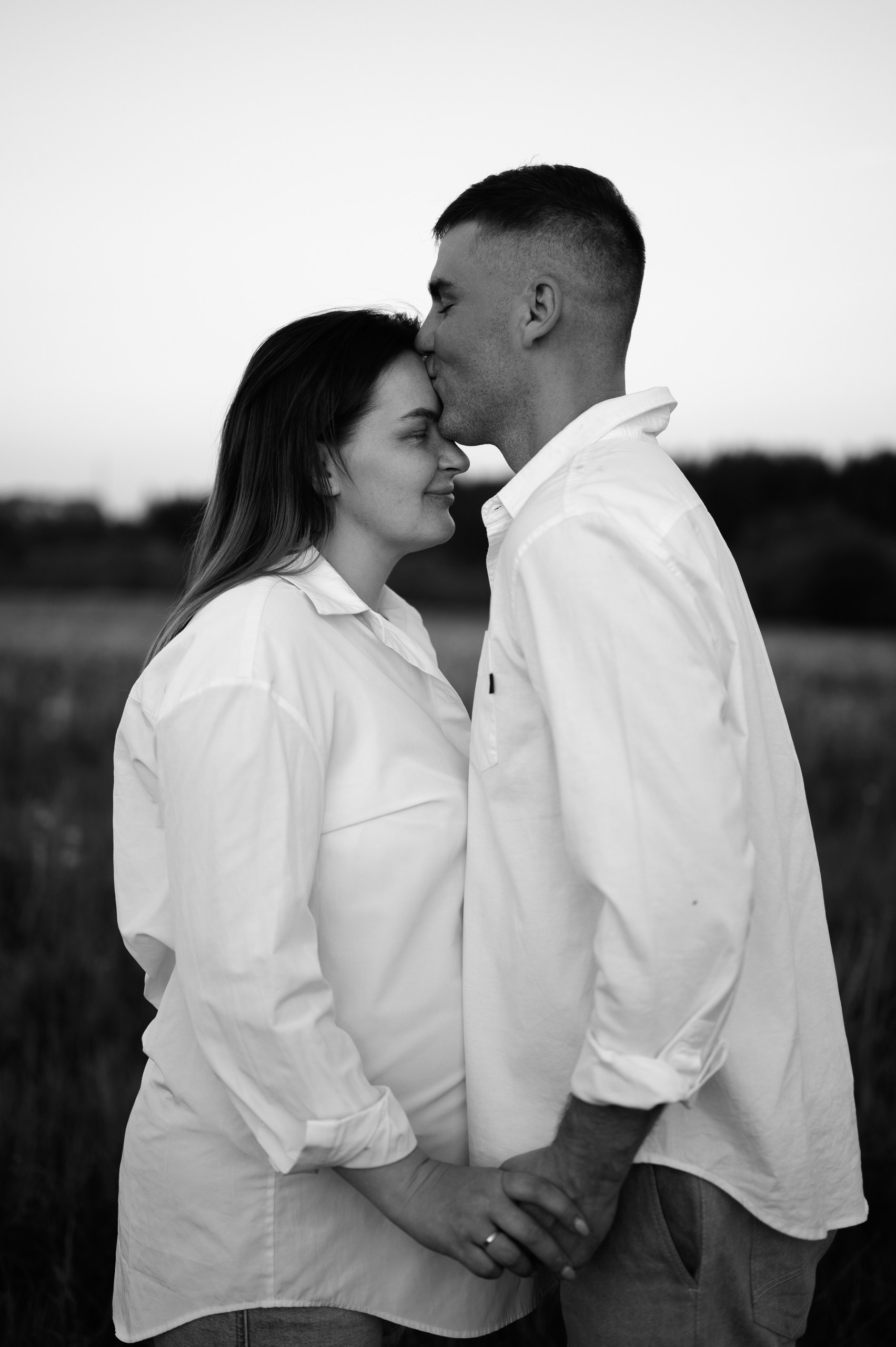 Парень целует в лоб на портретной фотосессии перед объективом фотографа