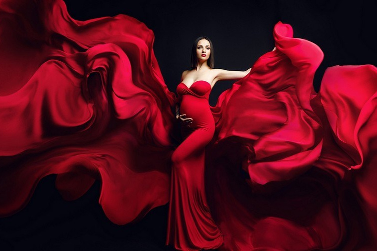 Фотосессия беременности Москва, беременная девушка в красном платье и летящей тканью.
