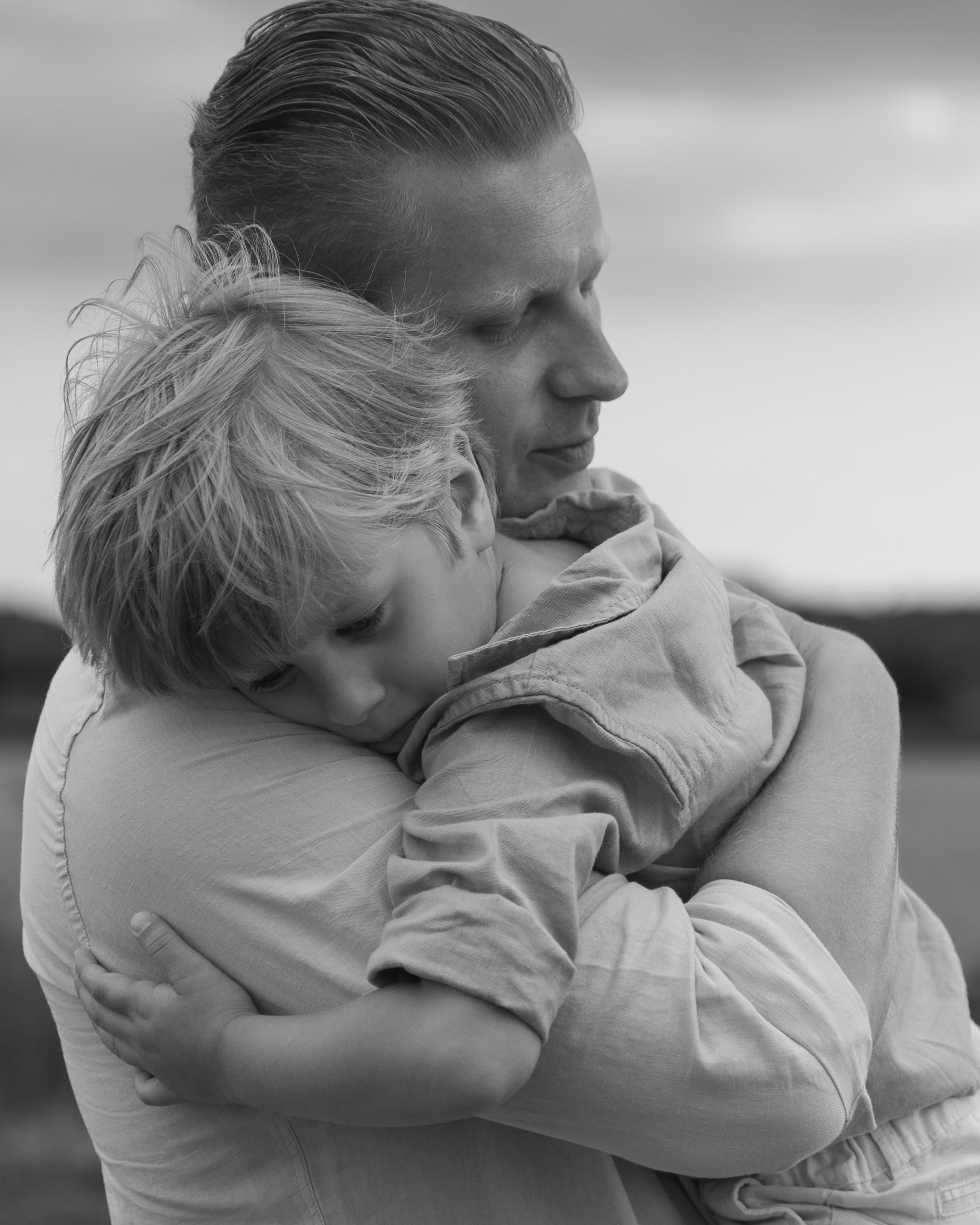 Séance photo famille dans le Gard, un père serre son enfant contre lui, photo en noir et blanc
