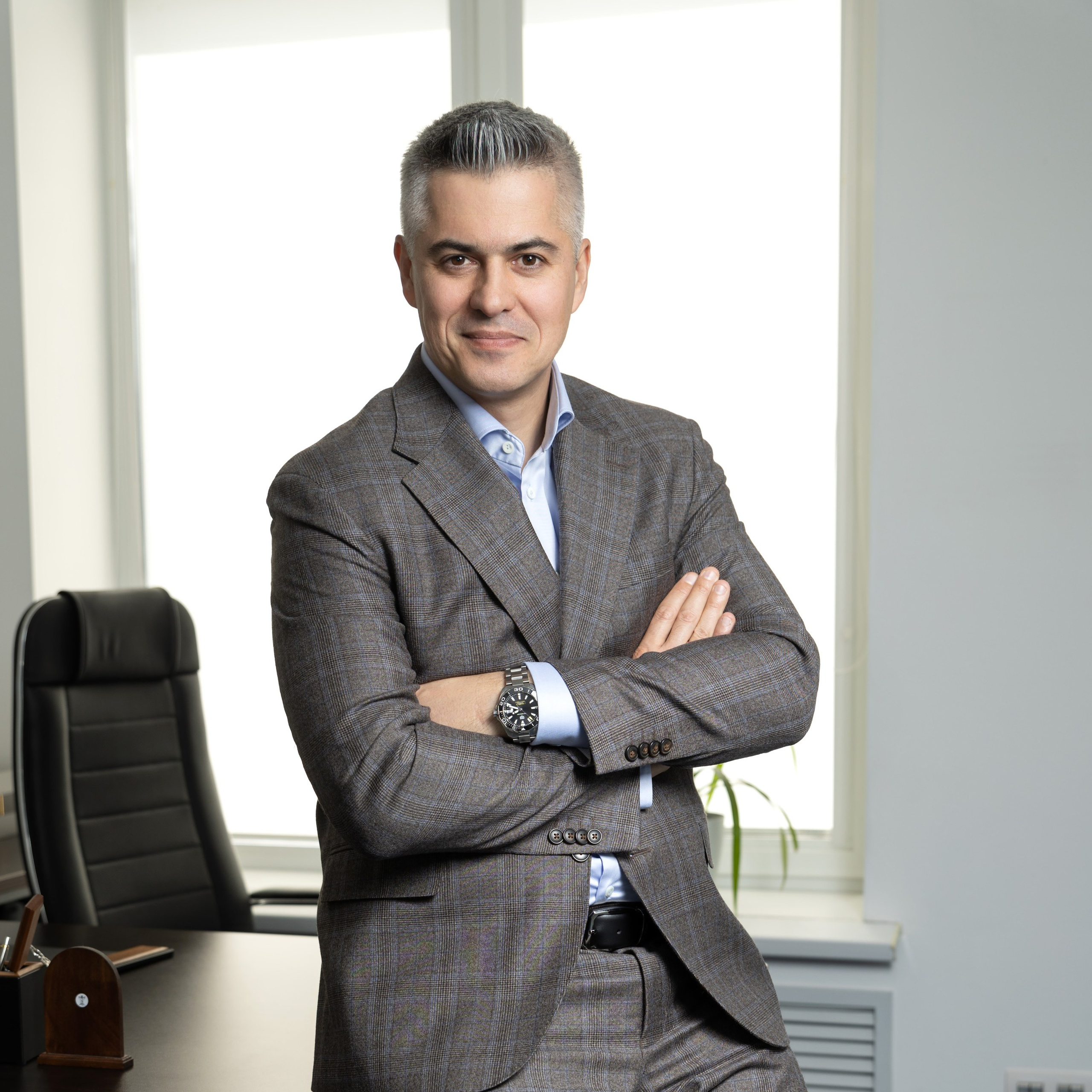 Мужчина в костюме сидит в кресле перед столом