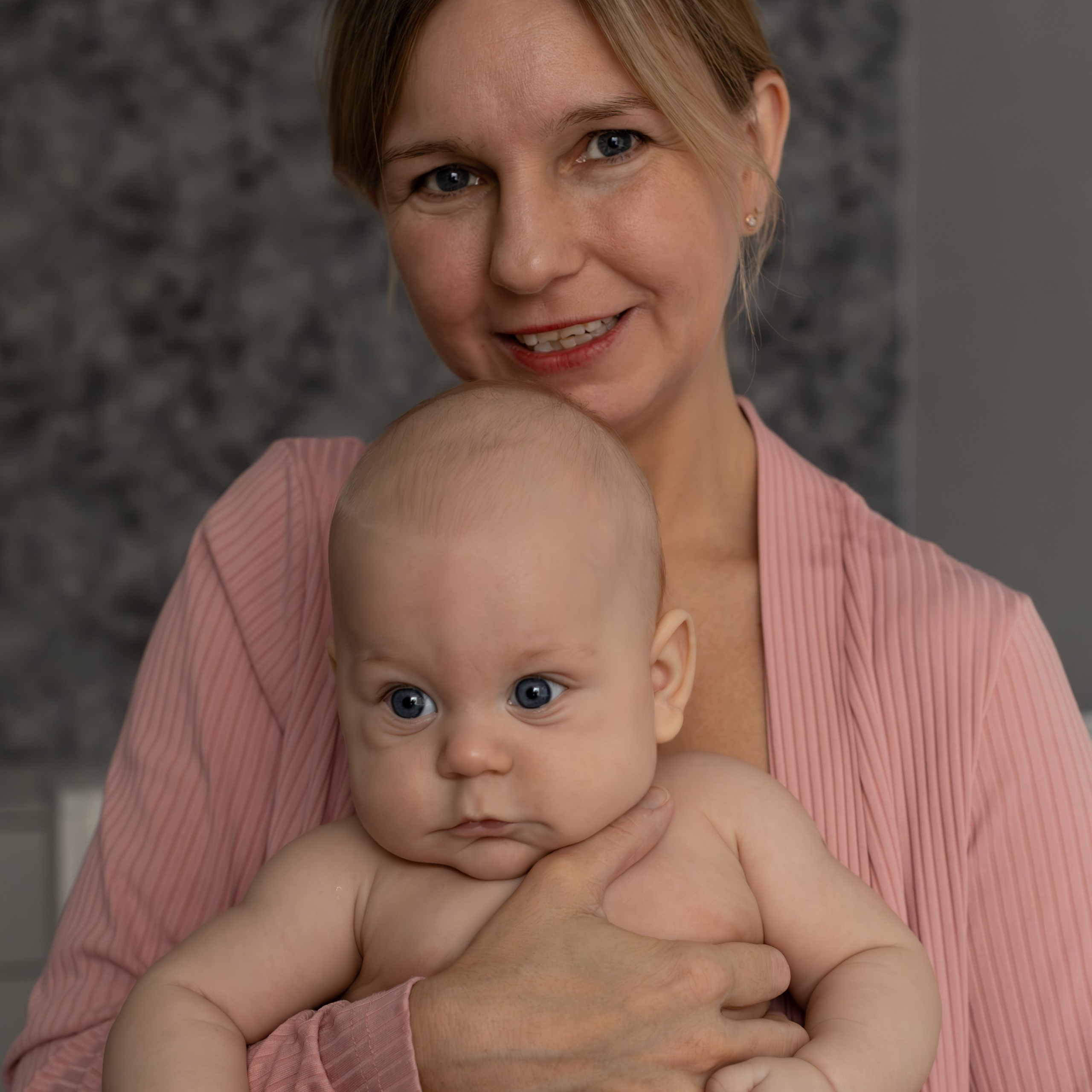 Домашняя фотосессия с новорождённым и детками постарше. На фотографии мама с малышом. 