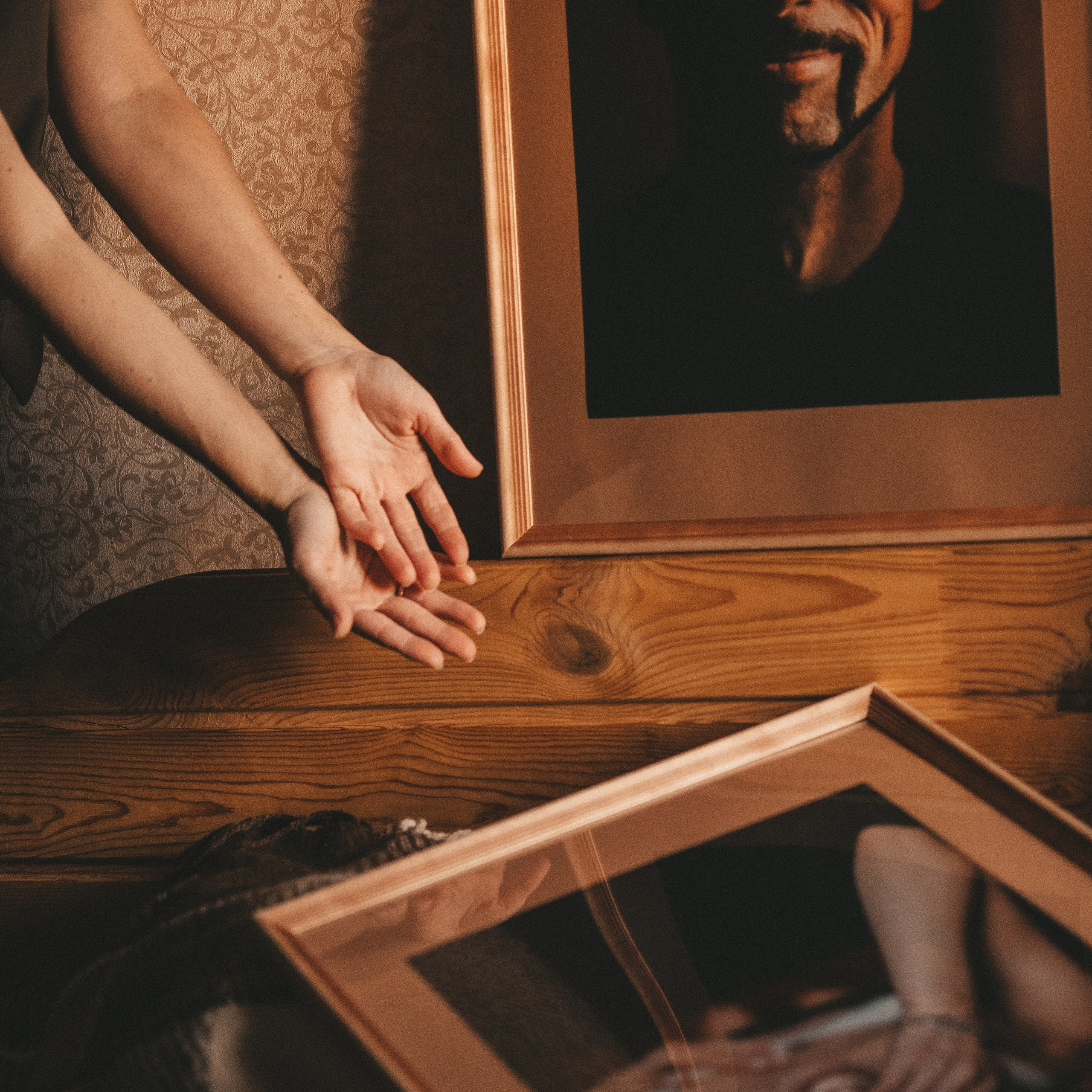 фотограф, его руки и его фотографии в рамках