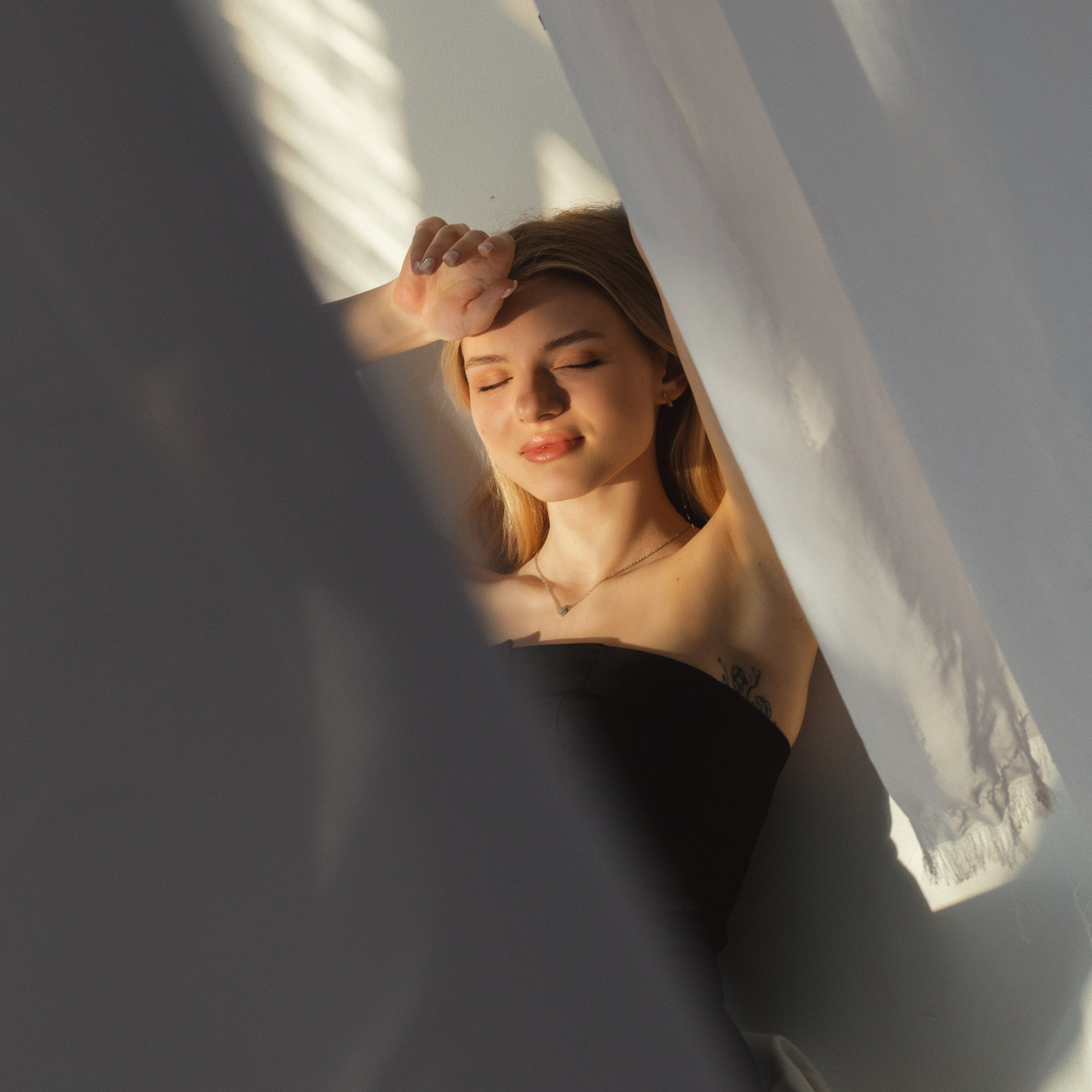 Портрет девушки, лежащей в лучах света на полу. Признак настоящей эмоциональной фотосессии.