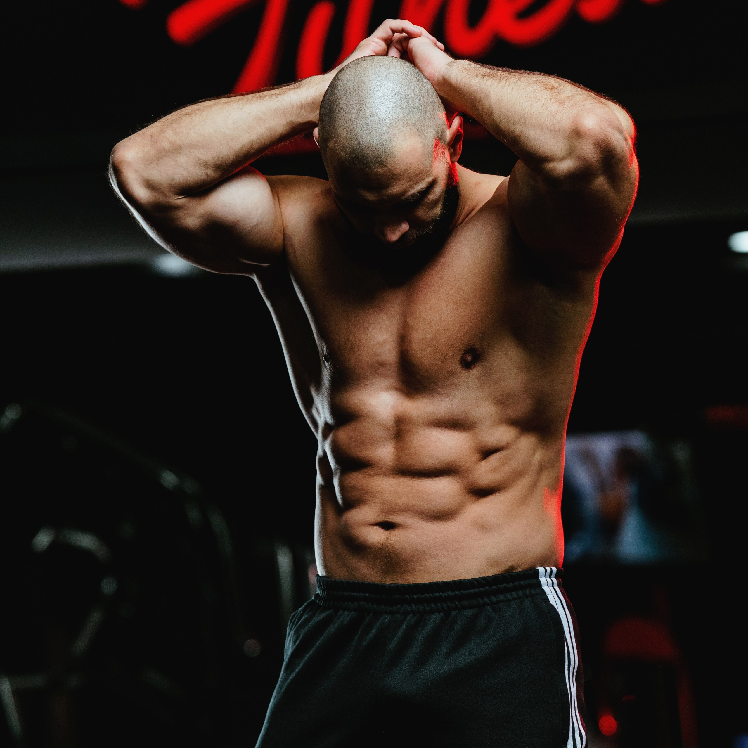 Спортивный молодой человек поднял руки над лысой головой