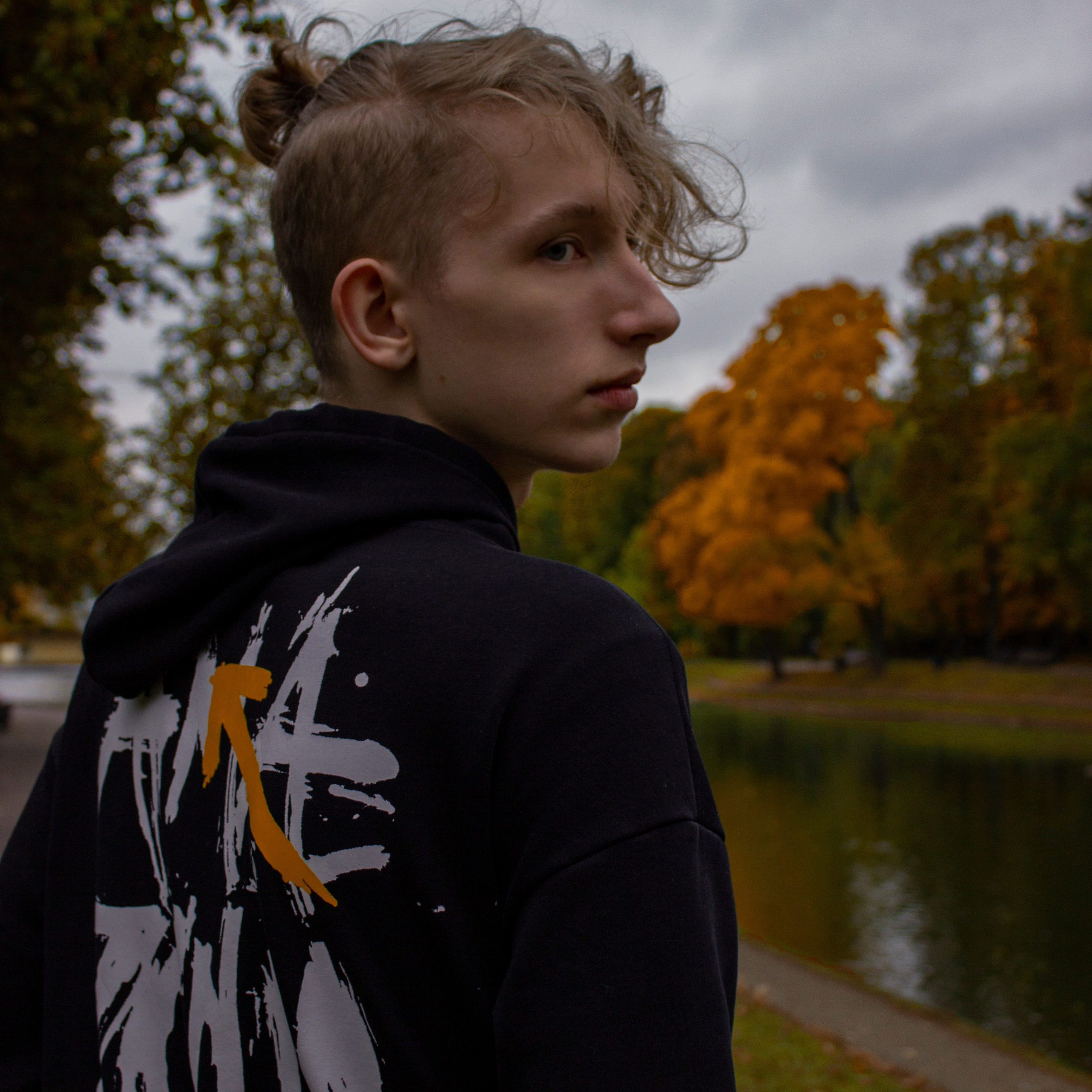 Кудрявый парень гуляет по осеннему парку