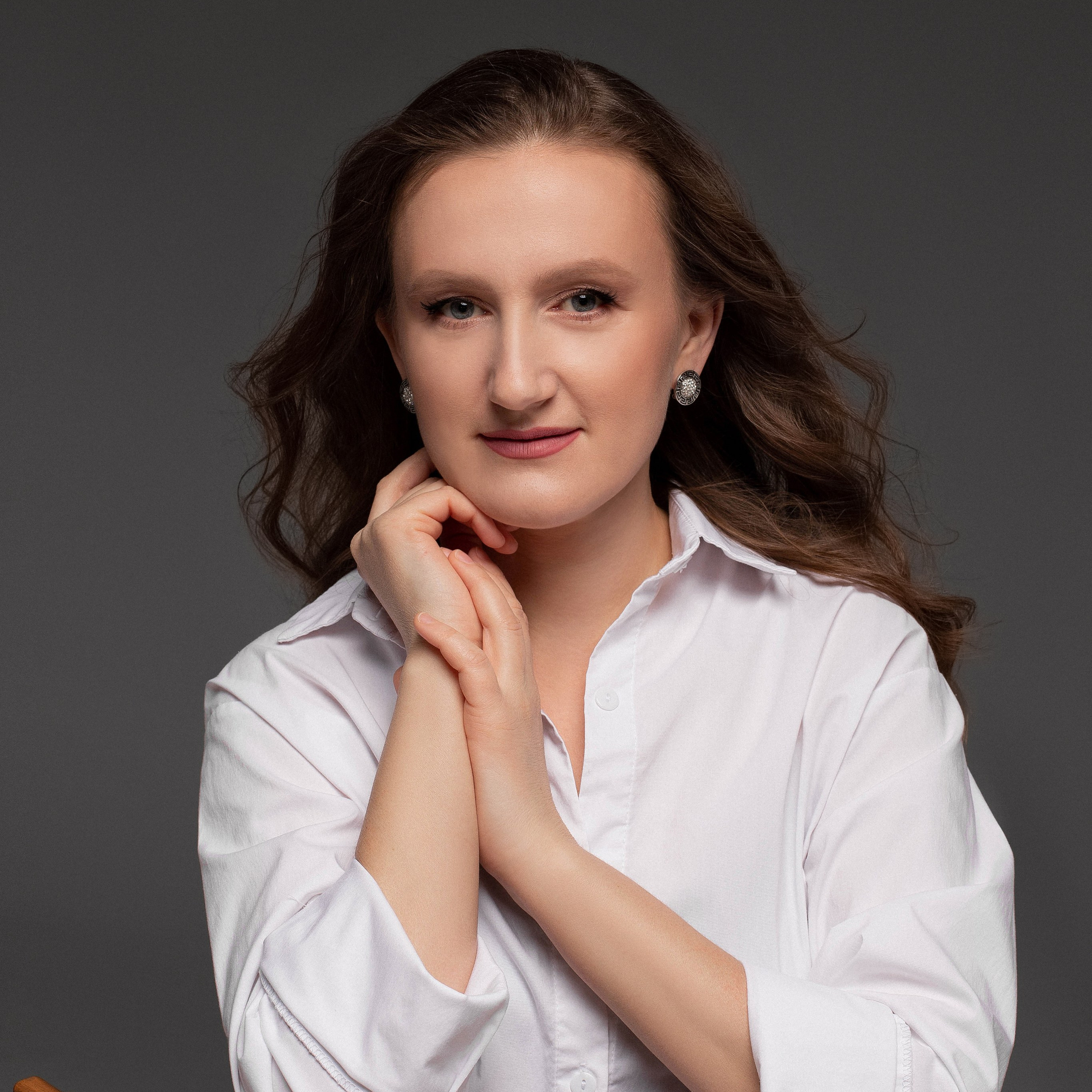 Молодая девушка-фотограф в красном пиджаке в студии