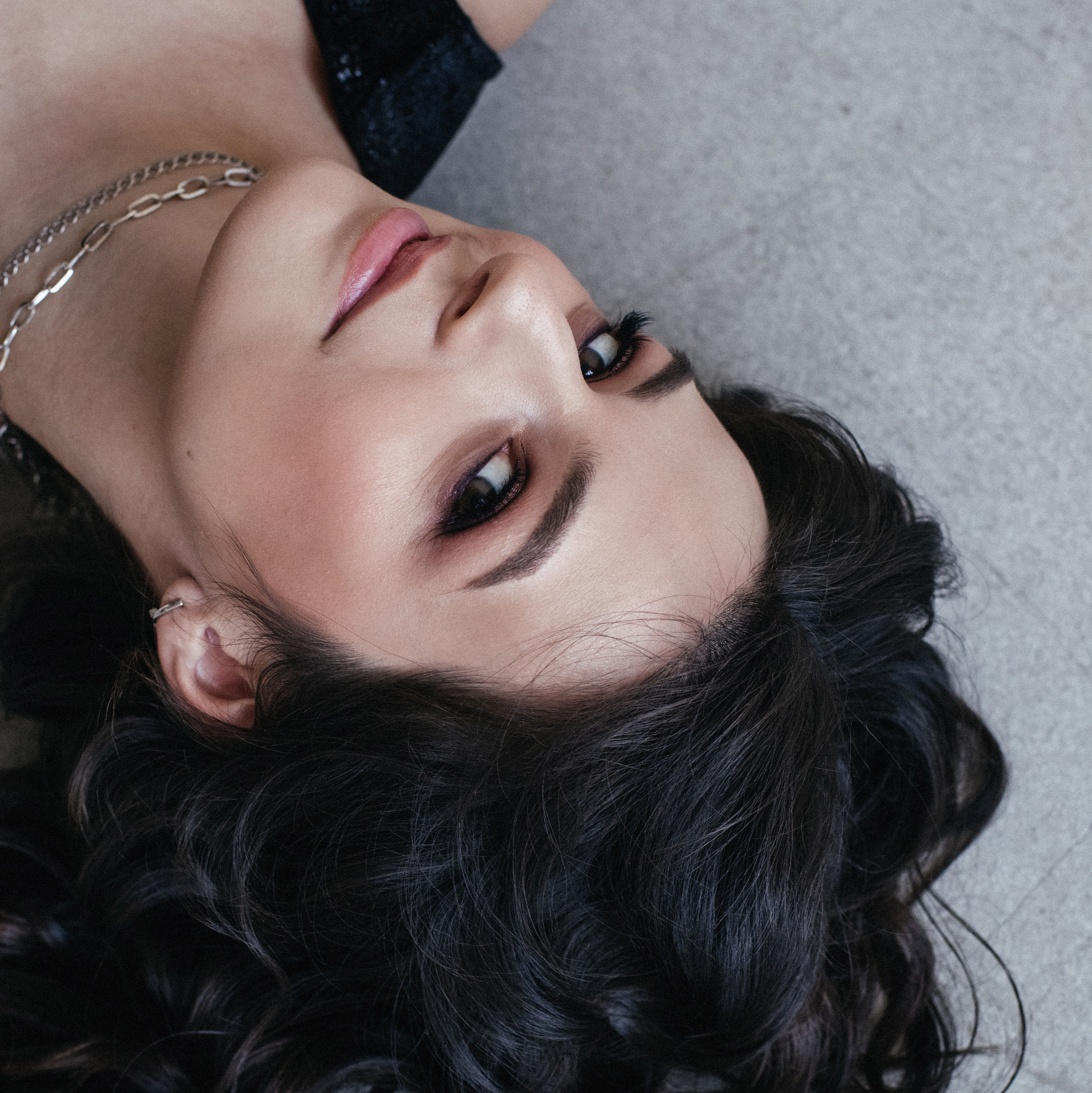 Женский портрет, девушка с кудрявыми волосами лежит на полу