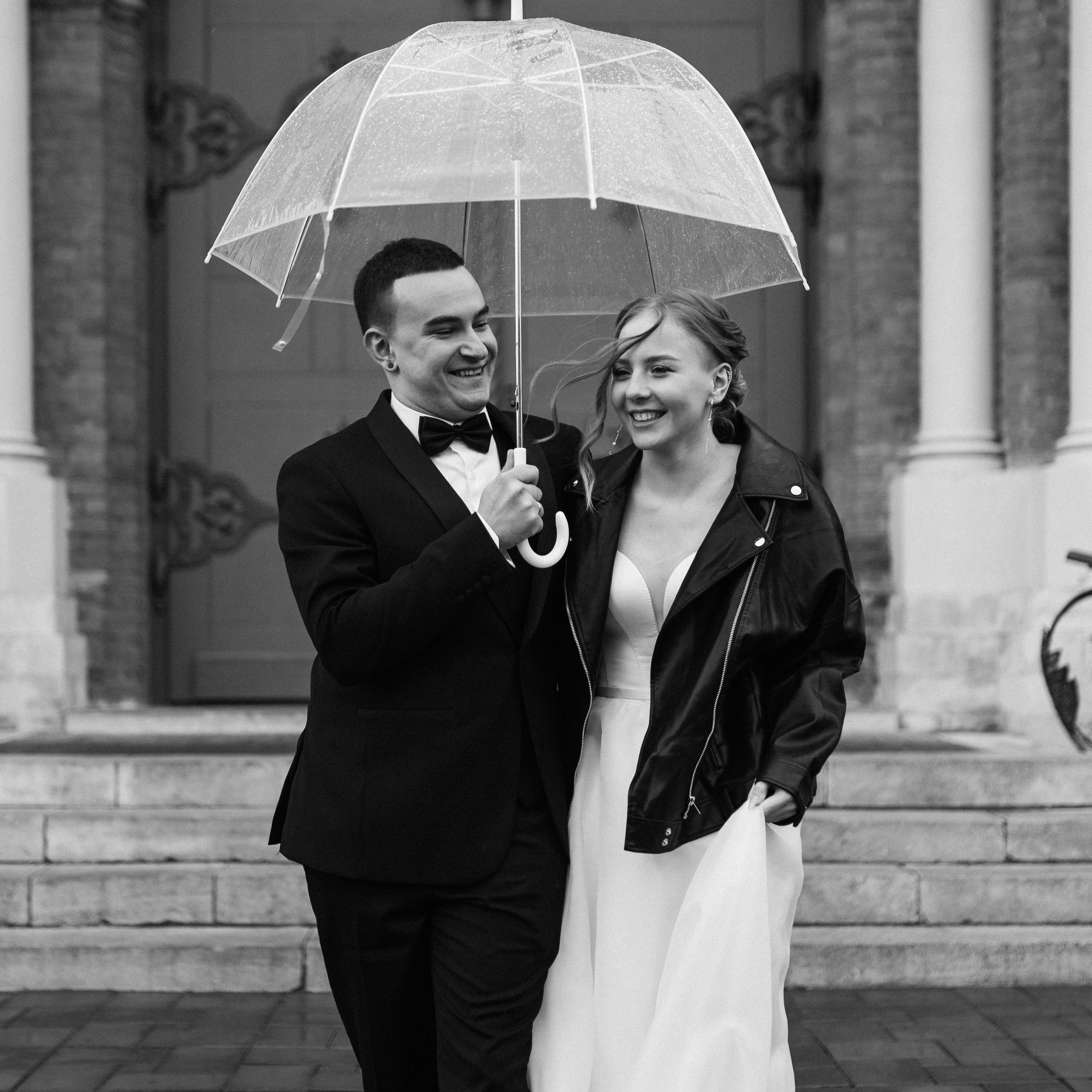 жених и невеста обнимаются на свадебной съёмке на заднем сидении кабриолета