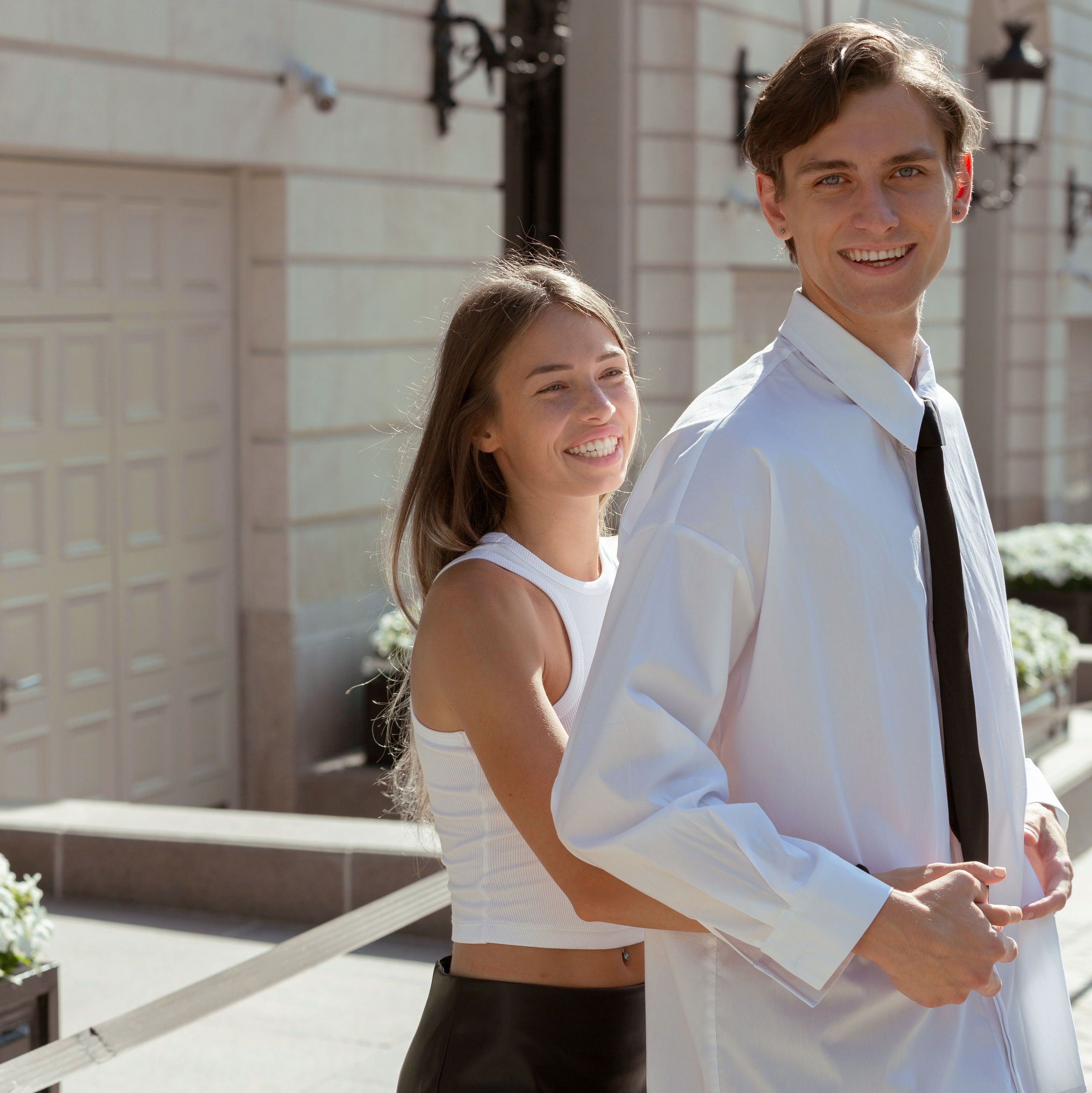 Пара стоит на улице, обнимается и улыбается. Сила живых воспоминаний в фотографиях.