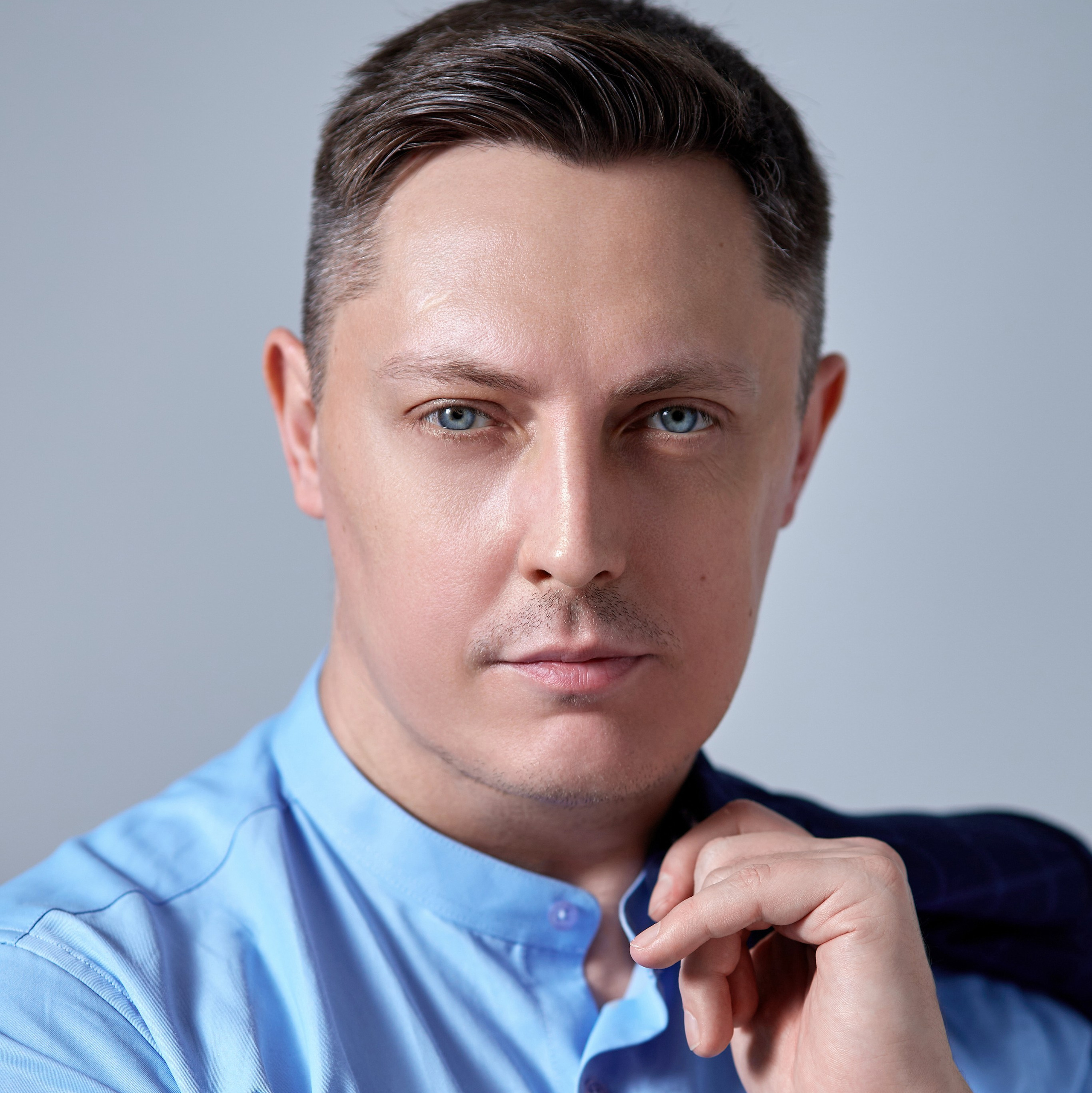 Репортажный фотограф Гера Урнев из города Москва позирует перед фотокамерой - фотография портрета московского фотографа с пиджаком в руке