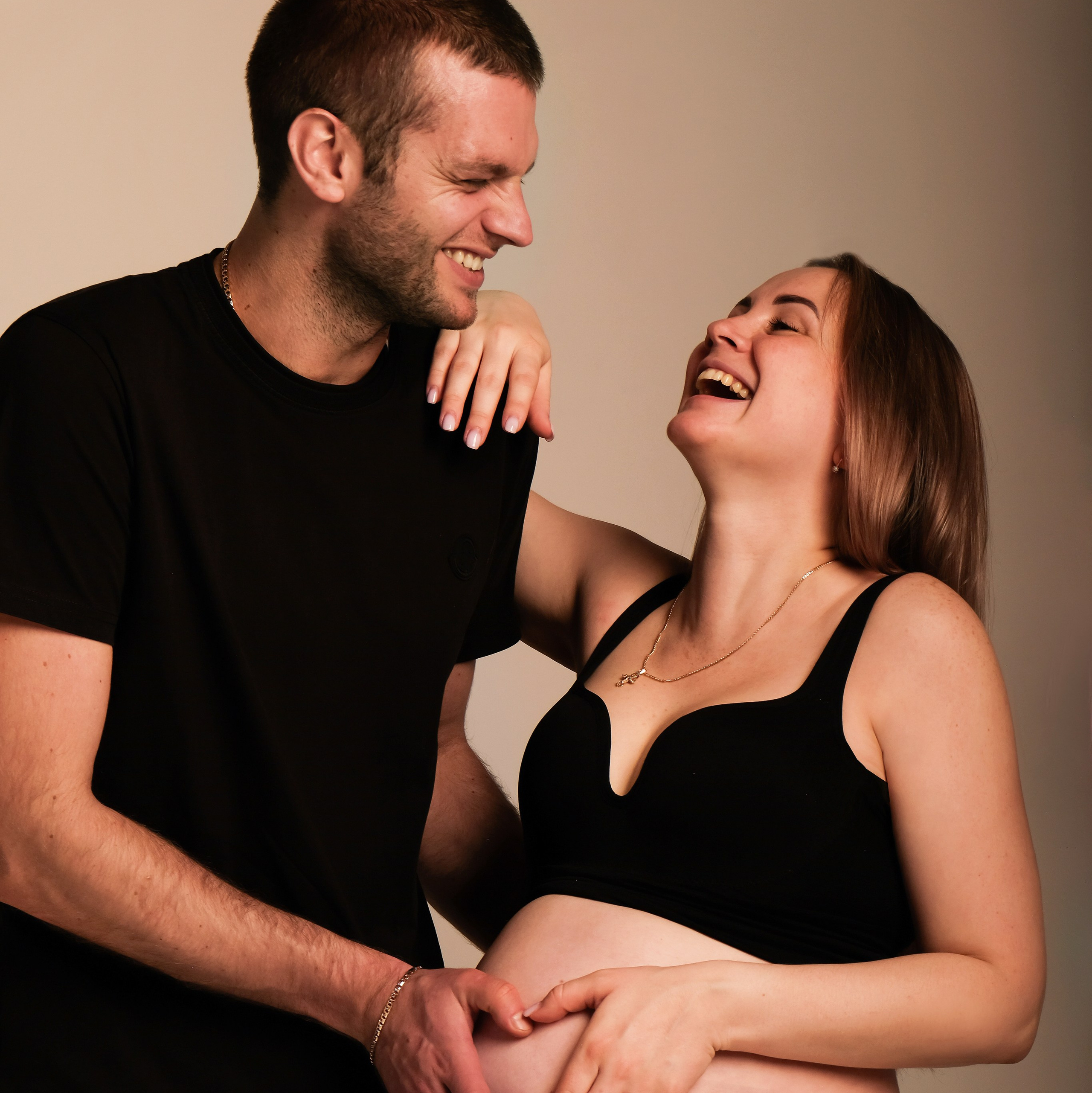 Беременная девушка с мужем смеются