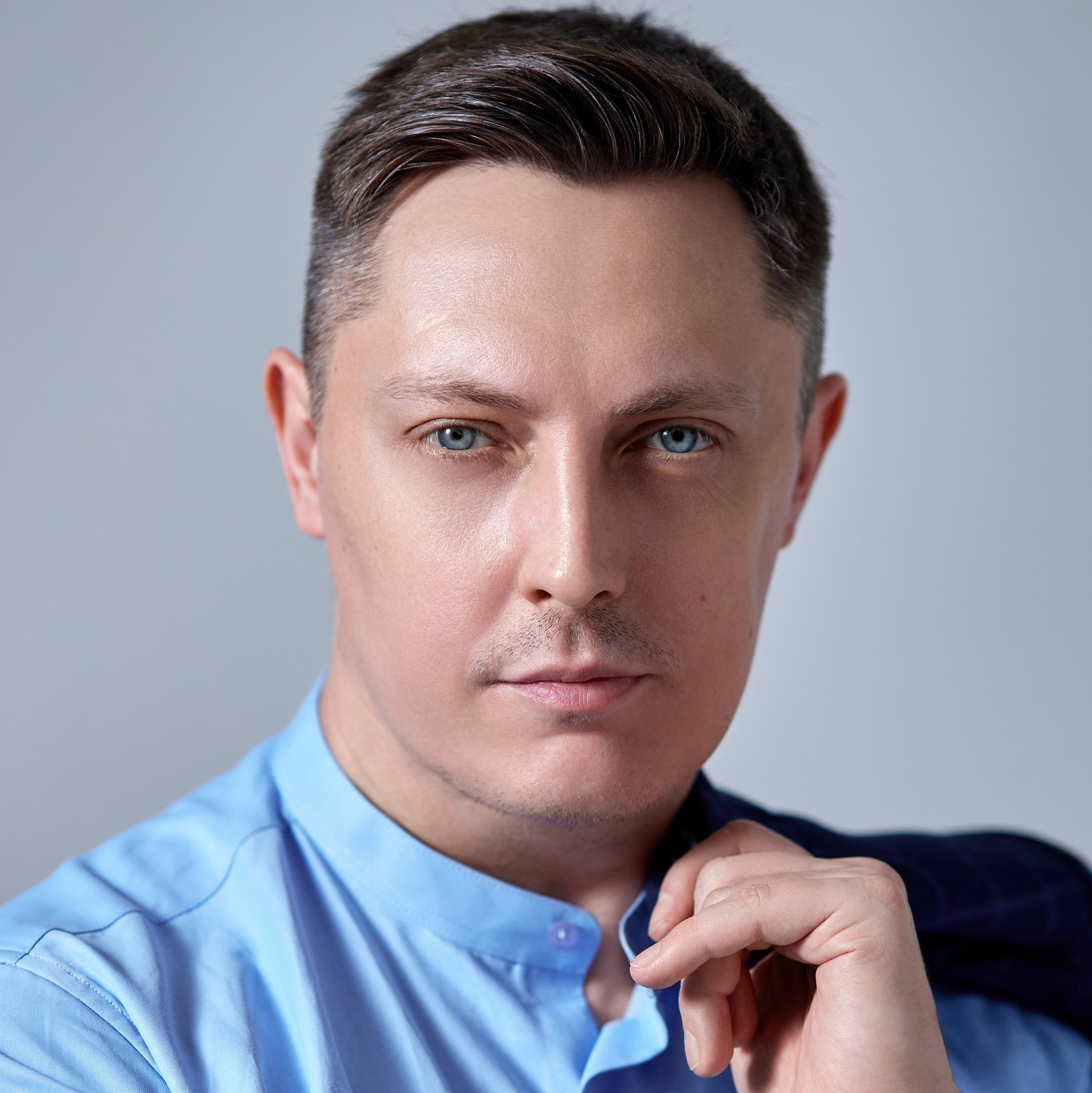 Профессиональный фотограф на семейную съемку Гера Урнев из города Москва позирует перед фотокамерой - фотография портрета московского фотографа с пиджаком в руке