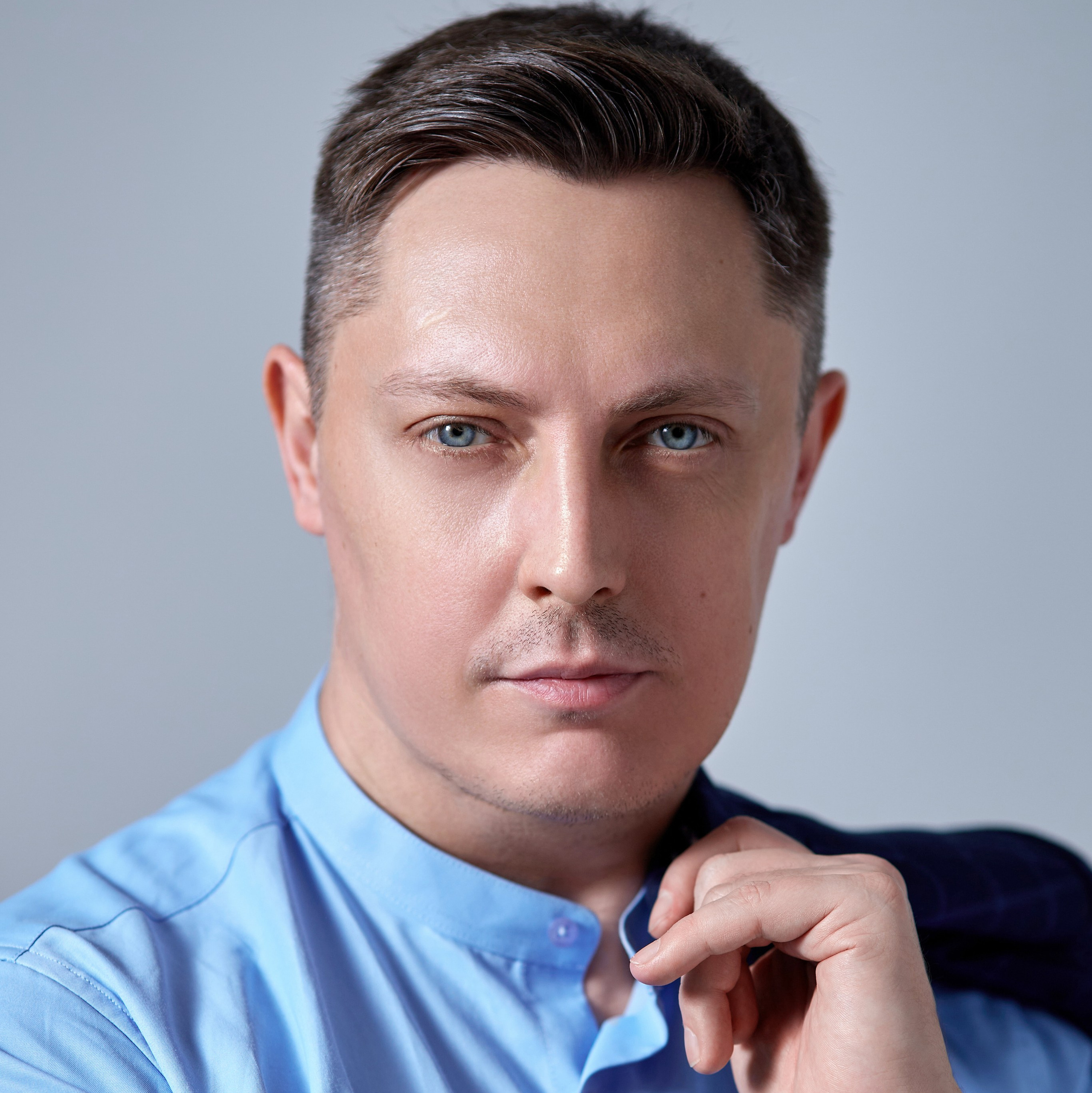 Профессиональный фотограф на индивидуальную съемку Гера Урнев из города Москва позирует перед фотокамерой - фотография портрета московского фотографа с пиджаком в руке