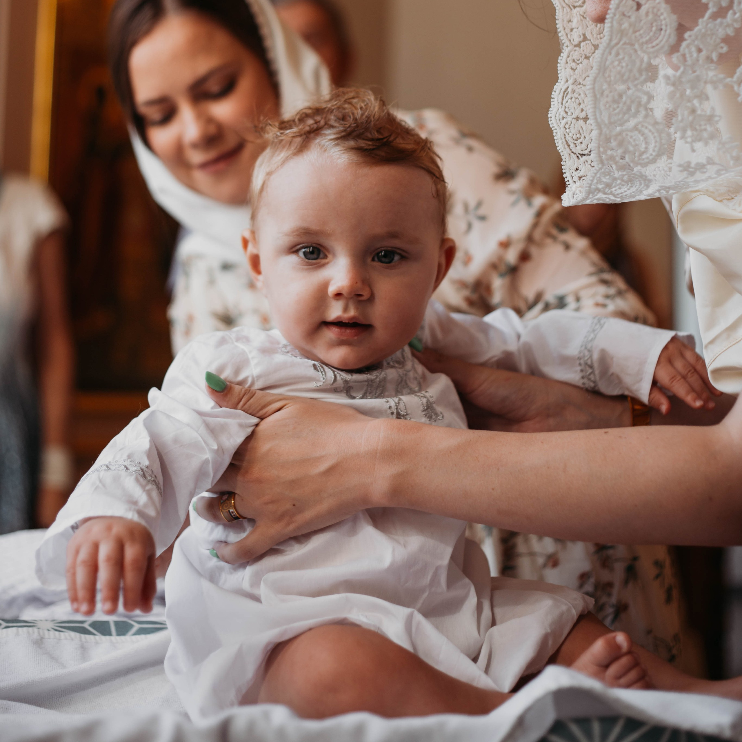 крещение в церкви полугодовалого малыша и заботливый поцелуй крестной