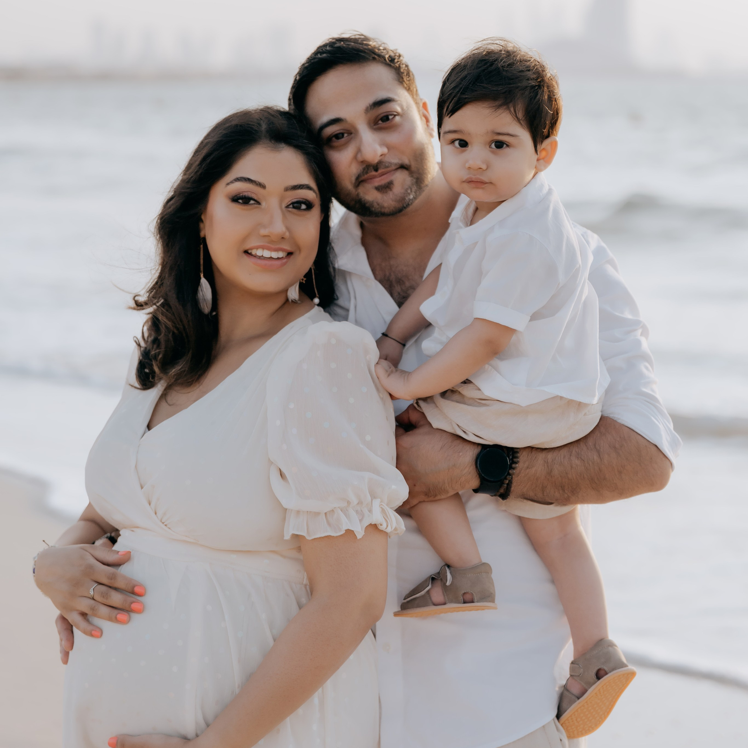 Young family with a toddler standing on a beach